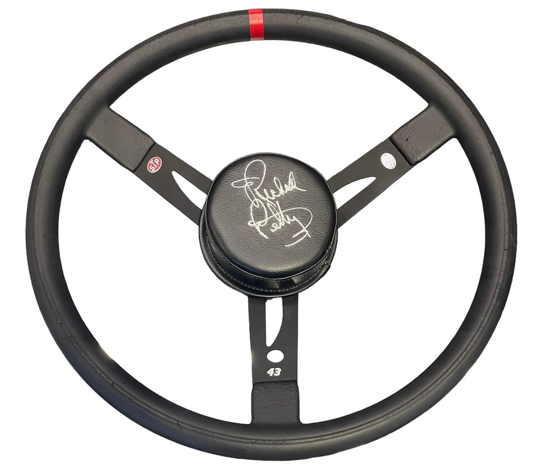 Richard Petty Autographed Replica Steering Wheel (JSA): Richard Petty Autographed Replica Steering Wheel (JSA) Signed in silver paint pen across the front of the wheel, this replica steering wheel bears the mark of Richard Petty's signature. Authenticity i