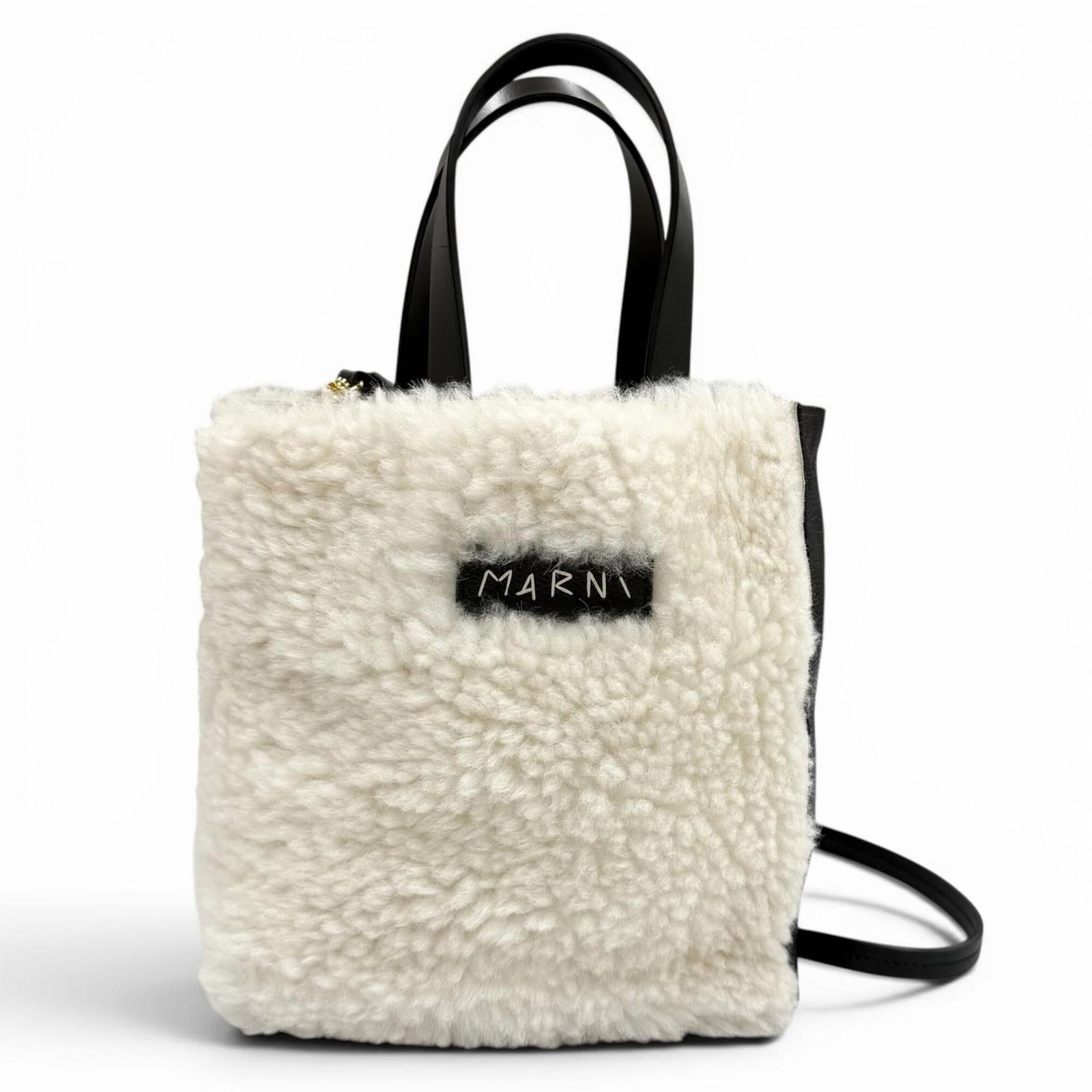 MARNI Shoulder Bag Fur Leather: MARNI Shoulder Bag Fur Leather Marni's luxurious fur leather shoulder bag boasts a sleek black and off-white color combination. Crafted from high-quality lamb fur and premium leather, this stylish bag