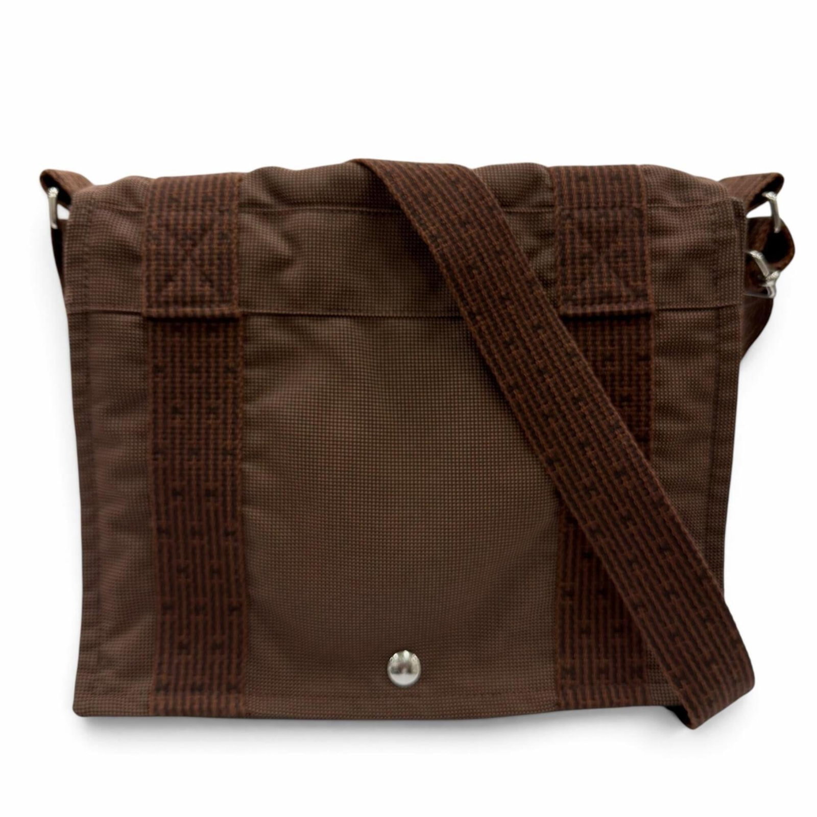 HERMES Shoulder Bag Polyamide Polyester: HERMES Shoulder Bag Polyamide Polyester The Hermes Shoulder Bag is a timeless piece crafted from high-quality polyamide and polyester materials, boasting a rich brown color and sleek silver hardware. 