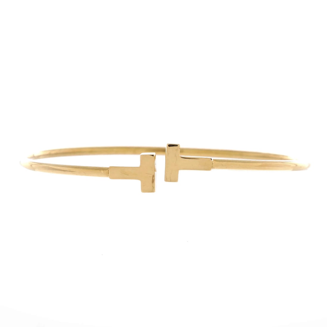 Tiffany & Co T Wire 18K Yellow Gold Narrow Bracelet: Tiffany & Co T Wire 18K Yellow Gold Narrow Bracelet Tiffany & Co's T Wire 18K Yellow Gold Narrow Bracelet is a sleek and sophisticated accessory featuring 18K yellow gold metal. The bracelet boasts a 