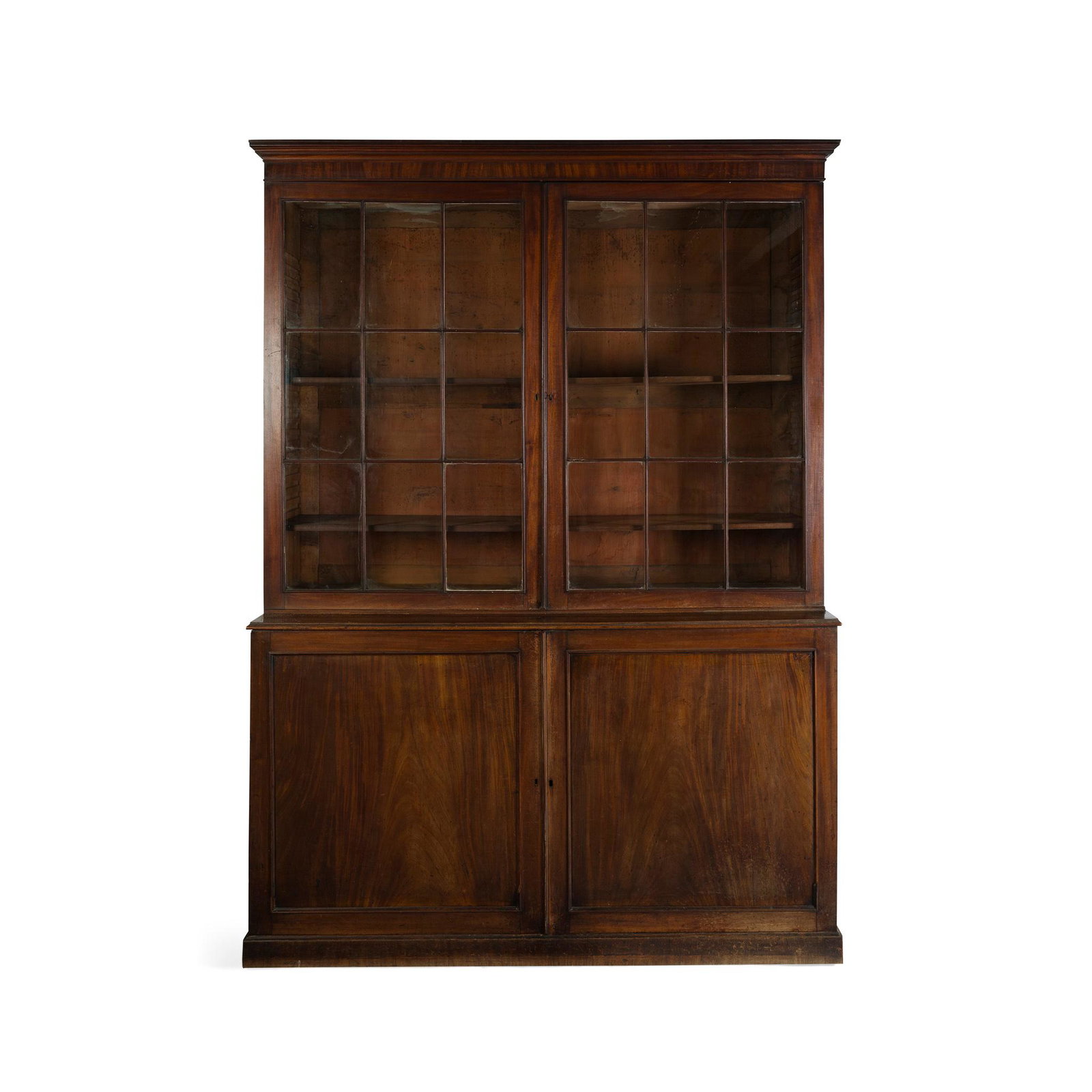GEORGE III MAHOGANY LIBRARY BOOKCASE LATE 18TH/ EARLY: the moulded cornice above a pair of astragal glazed doors, enclosing adjustable shelves; the lower part with a pair of panelled doors, on a plinth base (Dimensions: 186cm wide, 259cm high, 59cm deep) 