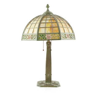 AMERICAN SCHOOL, MANNER OF HANDEL LAMP COMPANY TABLE: AMERICAN SCHOOL, MANNER OF HANDEL LAMP COMPANY TABLE LAMP, CIRCA 1910 the bronzed strapwork base surmounted by domed shade with slag glass panels (60cm high, 38.5cm wide)