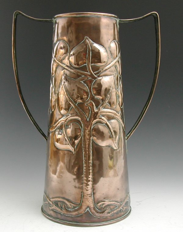 An Arts and Crafts copper twin handled vase, of t: An Arts and Crafts copper twin handled vase, of tapering form, repousse decorated in the manner of John Pearson with stylised tree forms 42cm high
