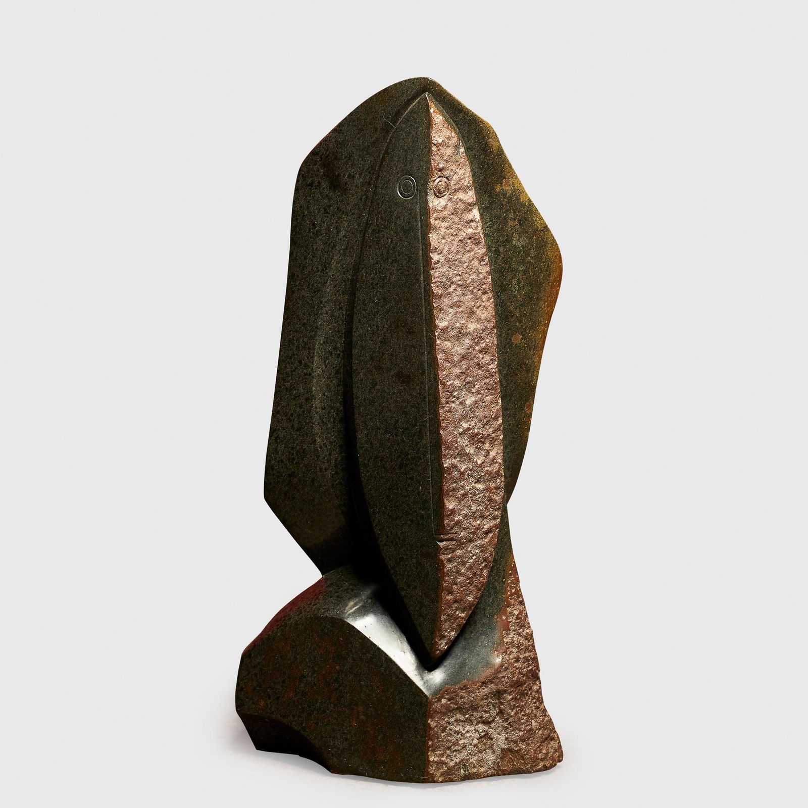 NICHOLAS MUKOMBERANWA (SHONA B.1940 - D.2002) SPIRIT: NICHOLAS MUKOMBERANWA (SHONA B.1940 - D.2002) SPIRIT MEDIUM, 1987 ZIMBABWE carved and polished brown serpentine, the elliptical face parted by a sharp central ridge, subtly incised ring eyes and short