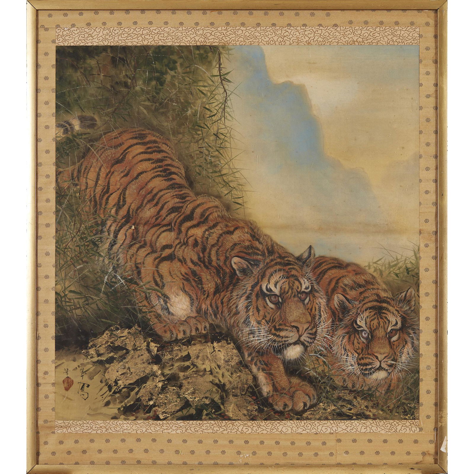 JAPANESE SILK PAINTING OF A PAIR OF TIGERS 20TH CENTURY: hand painted on silk with a separate silk border, depicting two crouching tigers moving down a steep bank with cloudy skies behind, the mark in the right corner indecipherable(80.5cm x 78cm)Footnote:
