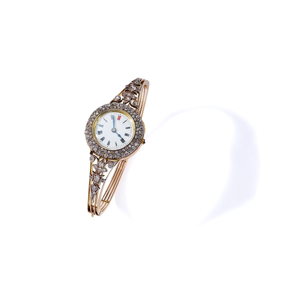 An early 20th century diamond watch bangle, circa 1907: An early 20th century diamond watch bangle, circa 1907 The circular white dial with Roman numerals and blued steel hands, within an old single-cut diamond double row surround, between tapered shoulder