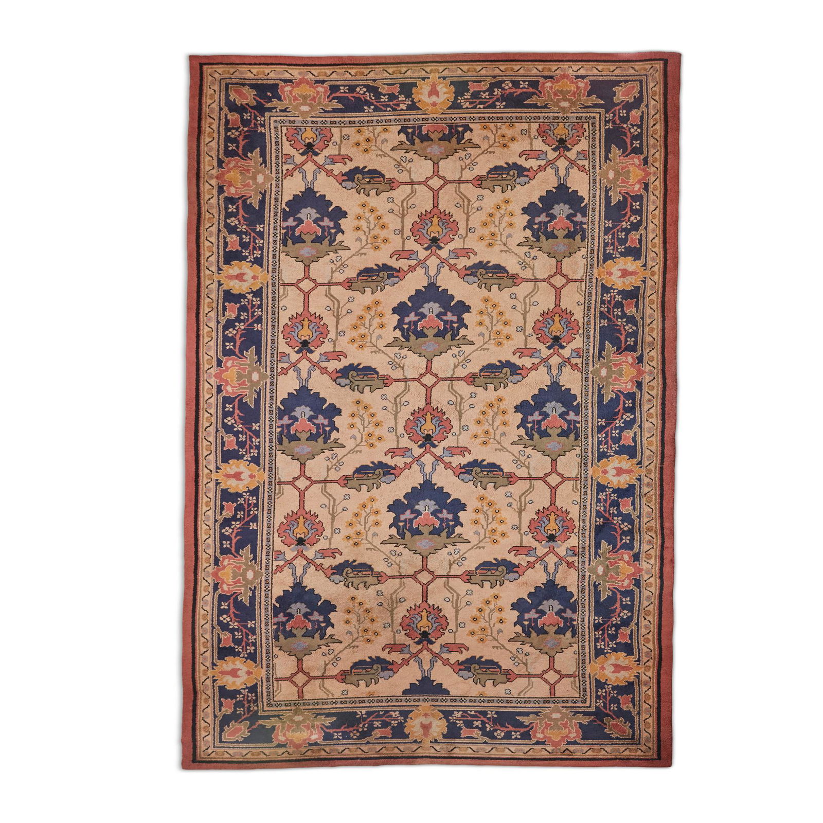 AFTER GAVIN MORTON AND G.K. ROBERTSON ARTS & CRAFTS HAND-KNOTTED CARPET: AFTER GAVIN MORTON AND G.K. ROBERTSON ARTS & CRAFTS HAND-KNOTTED CARPET wool, the ivory field having all-over decoration of bold palmettes and stiff leaves in blue, green and pastel enclosed by a conf