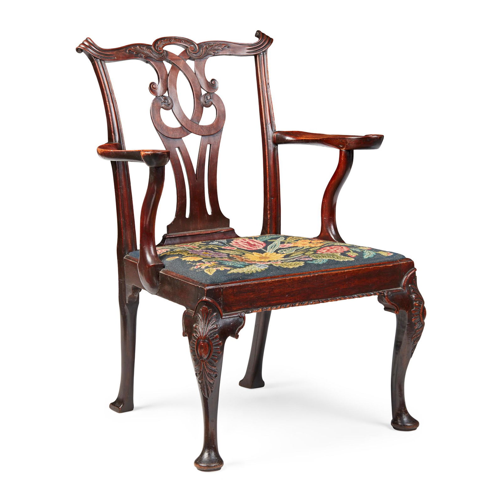 GEORGE III MAHOGANY ARMCHAIR, IN THE MANNER OF THOMAS CHIPPENDALE MID 18TH CENTURY: of large size, the shaped top rail carved with rocaille and fluted scrolled terminals, above a pierced interlaced splat and needlework drop-in seat flanked by scrolled arms on serpentine supports, rai