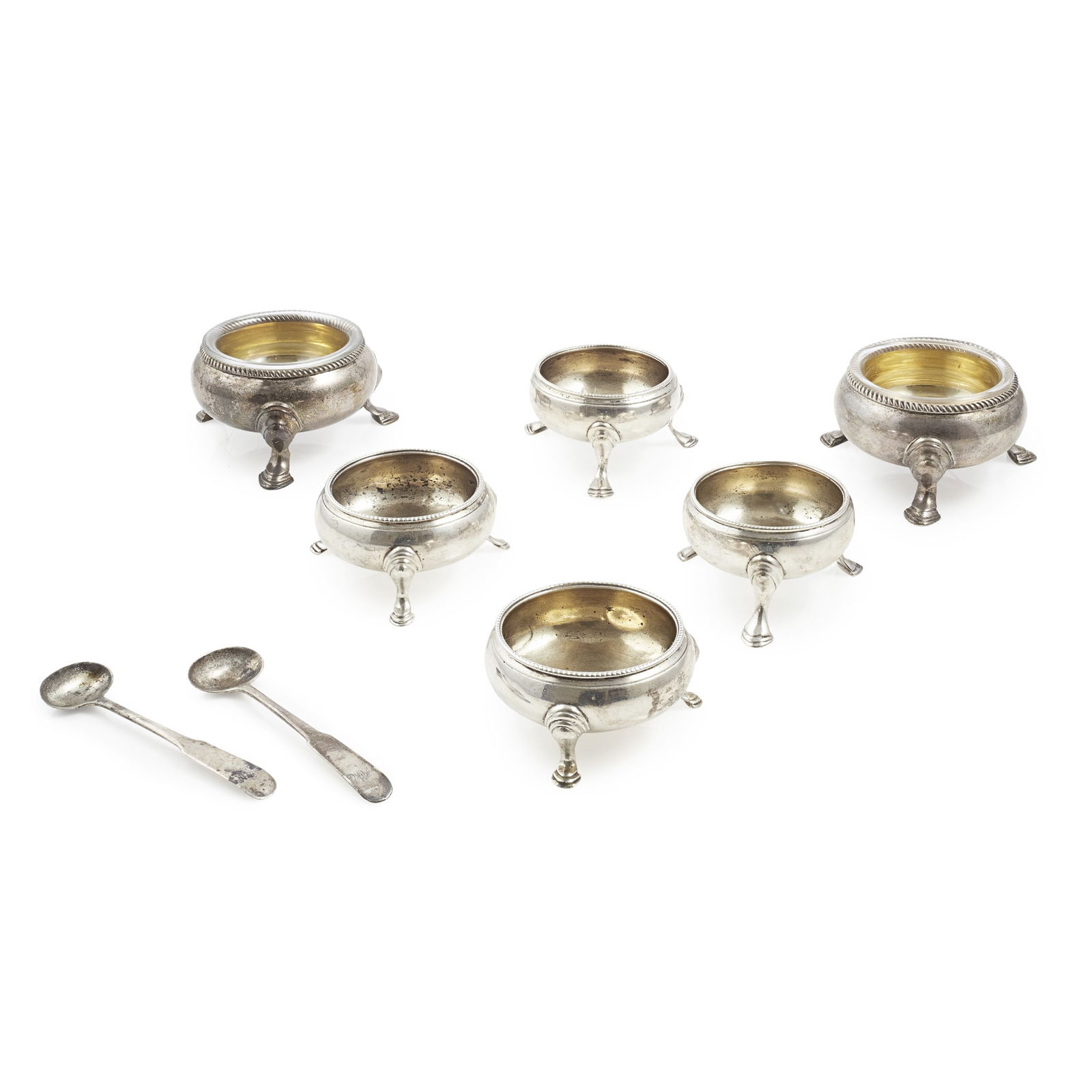 A pair of George II salts: A pair of George II salts James Smith, London 1733, of circular form, gadrooned border, gilt interior and glass liners, raised on three hoof feet; together with four matched circular salts and a pair
