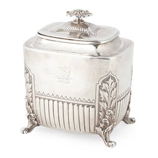 A Victorian tea caddy: A Victorian tea caddy Mappin & Webb, London 1886, of demi-fluted rounded rectangular form, engraved crest to body, raised on four acanthus clasped scroll feet, the pull-off lid with floral finial 