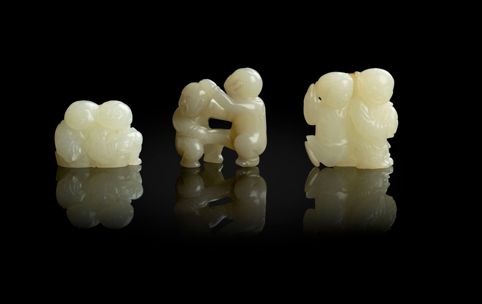 GROUP OF THREE JADE CARVINGS OF BOYS AT PLAY (1 of 2)