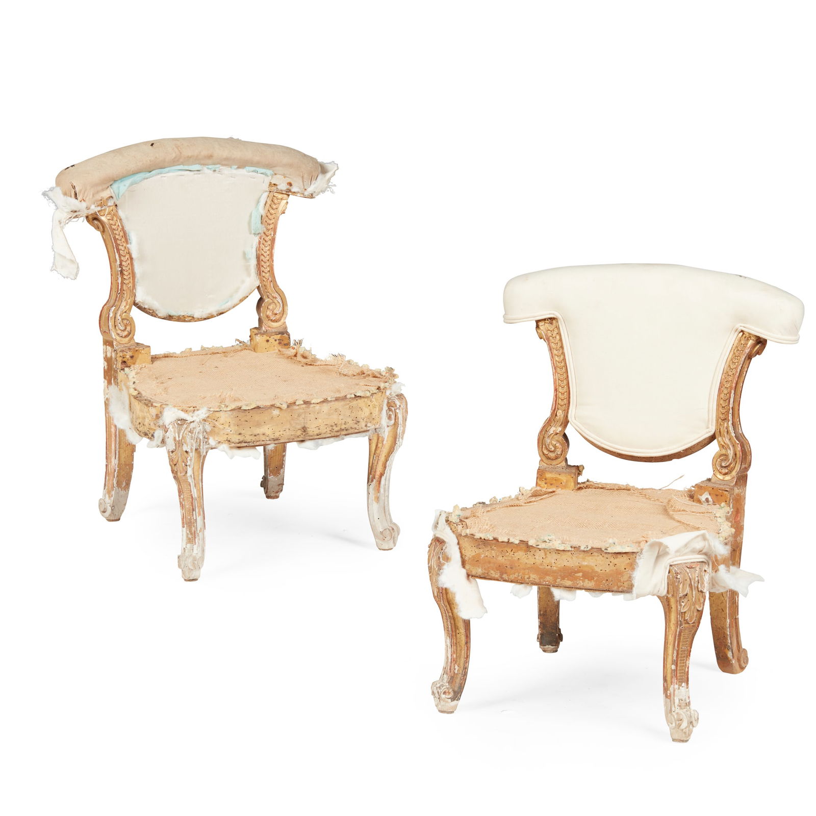 PAIR OF GEORGE II GILTWOOD LOW CHAIRS, IN THE MANNER OF WILLIAM KENT: PAIR OF GEORGE II GILTWOOD LOW CHAIRS, IN THE MANNER OF WILLIAM KENT 18TH CENTURY the padded backs with arched toprails and curved carved gilt uprights, over wide seats, the upholstery lacking, and ra