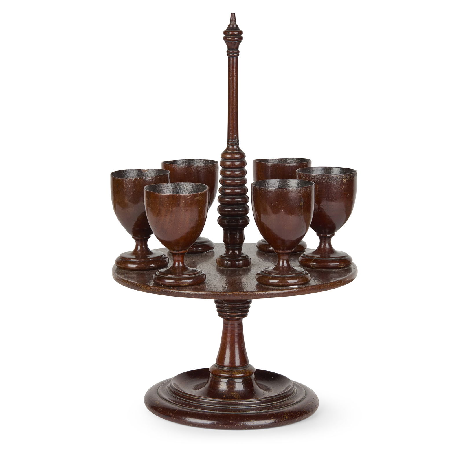 GEORGE III PERIOD: GEORGE III PERIOD TREEN EGG CUP STAND, LATE 18TH/ EARLY 19TH CENTURY with six egg cups and a stand with a central stem handle 29cm high (11 ½in high)