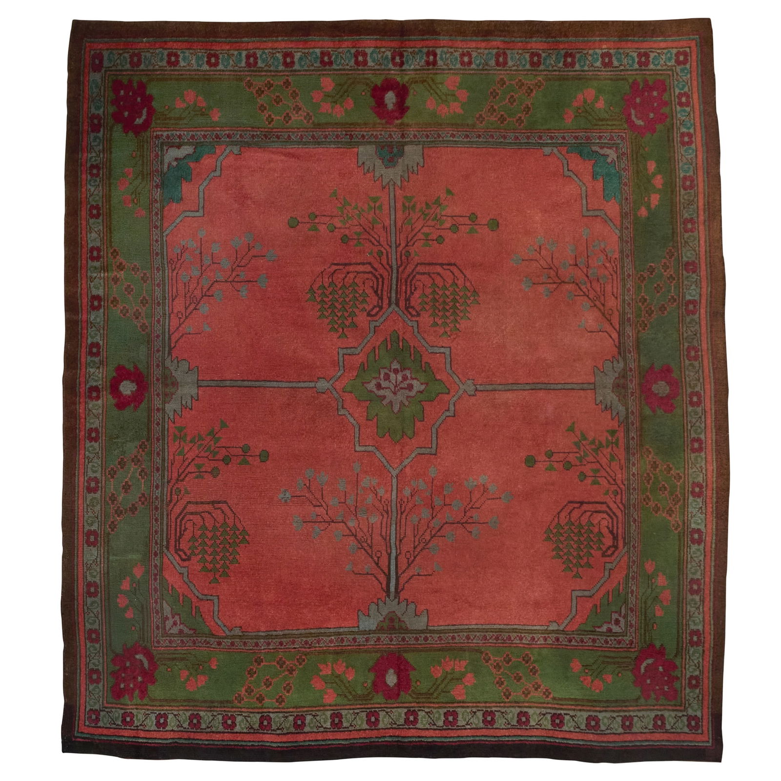 GAVIN MORTON (1867-1954) AND G. K. ROBERTSON FOR ALEXANDER MORTON & CO.: GAVIN MORTON (1867-1954) AND G. K. ROBERTSON FOR ALEXANDER MORTON & CO. ARTS & CRAFTS DONEGAL CARPET, CIRCA 1900 wool, the salmon pink field with green medallion, within green border 351cm x 301cm Ale