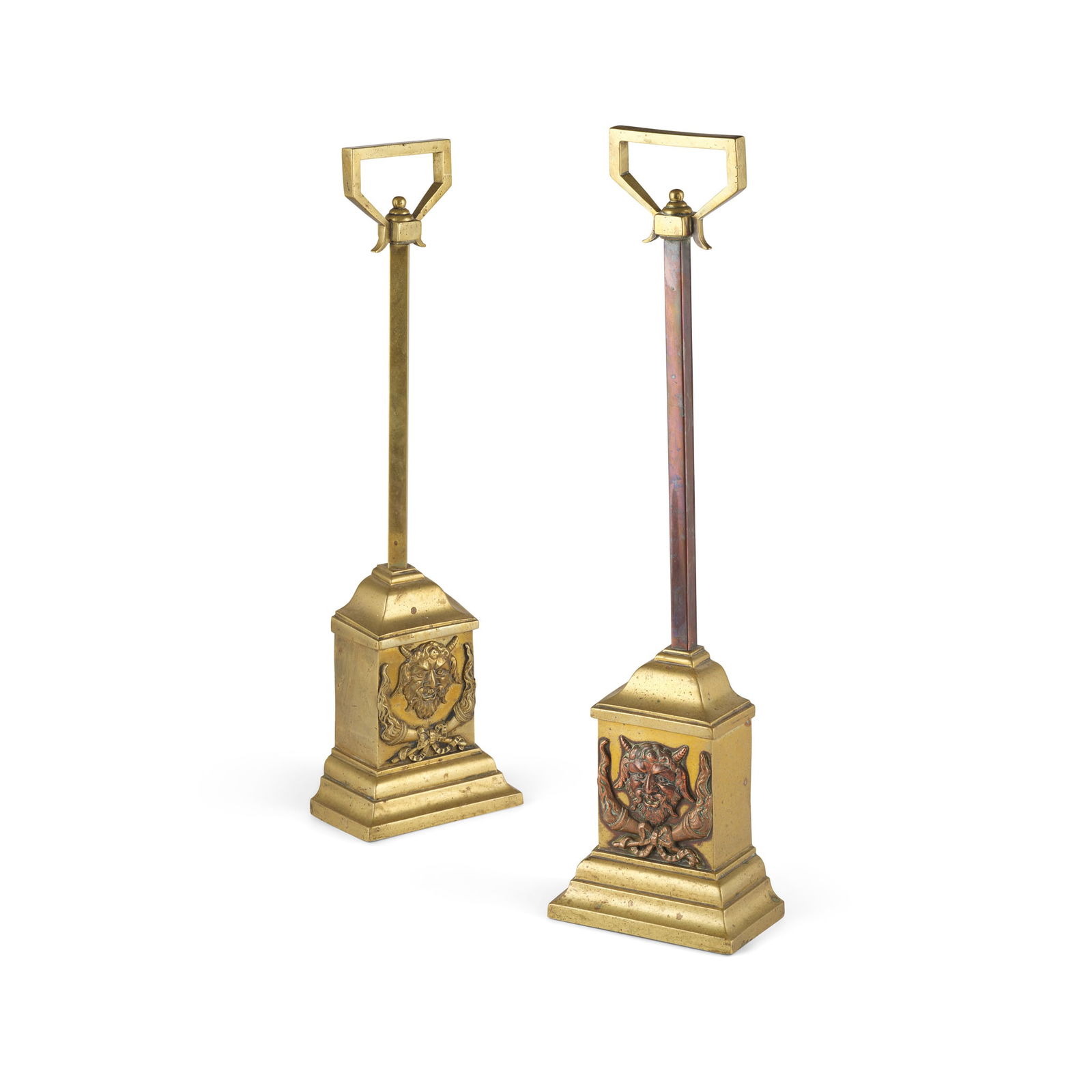 NEAR PAIR OF BRASS AND COPPER DOORSTOPS: NEAR PAIR OF BRASS AND COPPER DOORSTOPS 19TH CENTURY the weighted bases each cast with satyr mask over crossed flambeaux, on a moulded plinth base, with a square section stem and handle (2) 49cm high,
