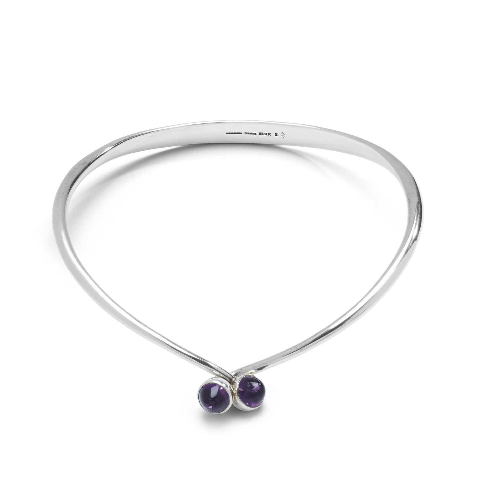 § Bent Knudsen: A silver and amethyst torc necklace: Bent Knudsen: A silver and amethyst torc necklace The plain polished torc terminating in bullet-shaped amethyst cabochons, signed BENTK Inner diameter: 11.5cm