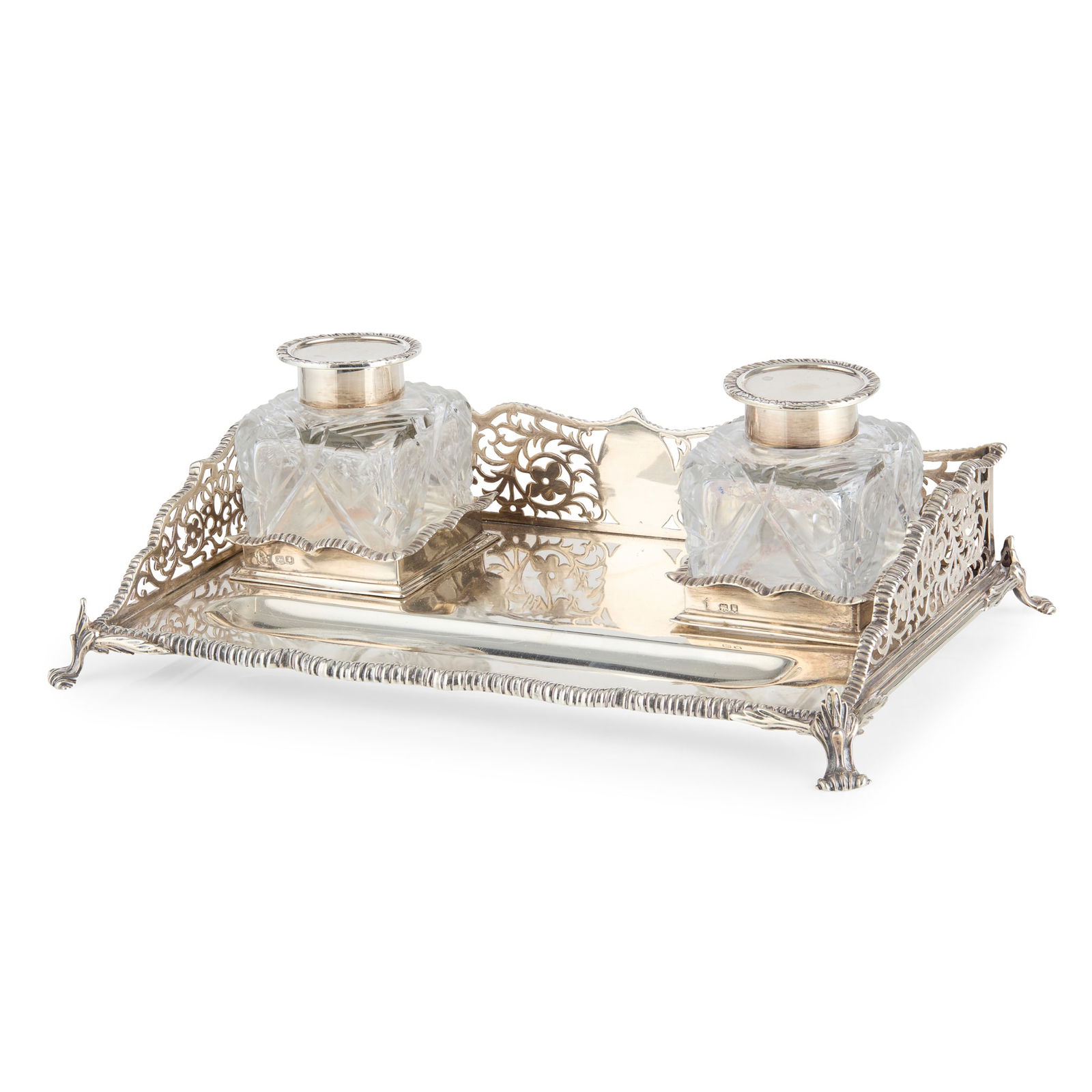 A GEORGE V GALLERY INKSTAND: A GEORGE V GALLERY INKSTAND CHARLES STUART HARRIS, LONDON 1916 of rectangular form, the pierced sides with a gadrooned border, two glass inkwells and a pen rest, all raised on scroll feet 26cm wide, 2