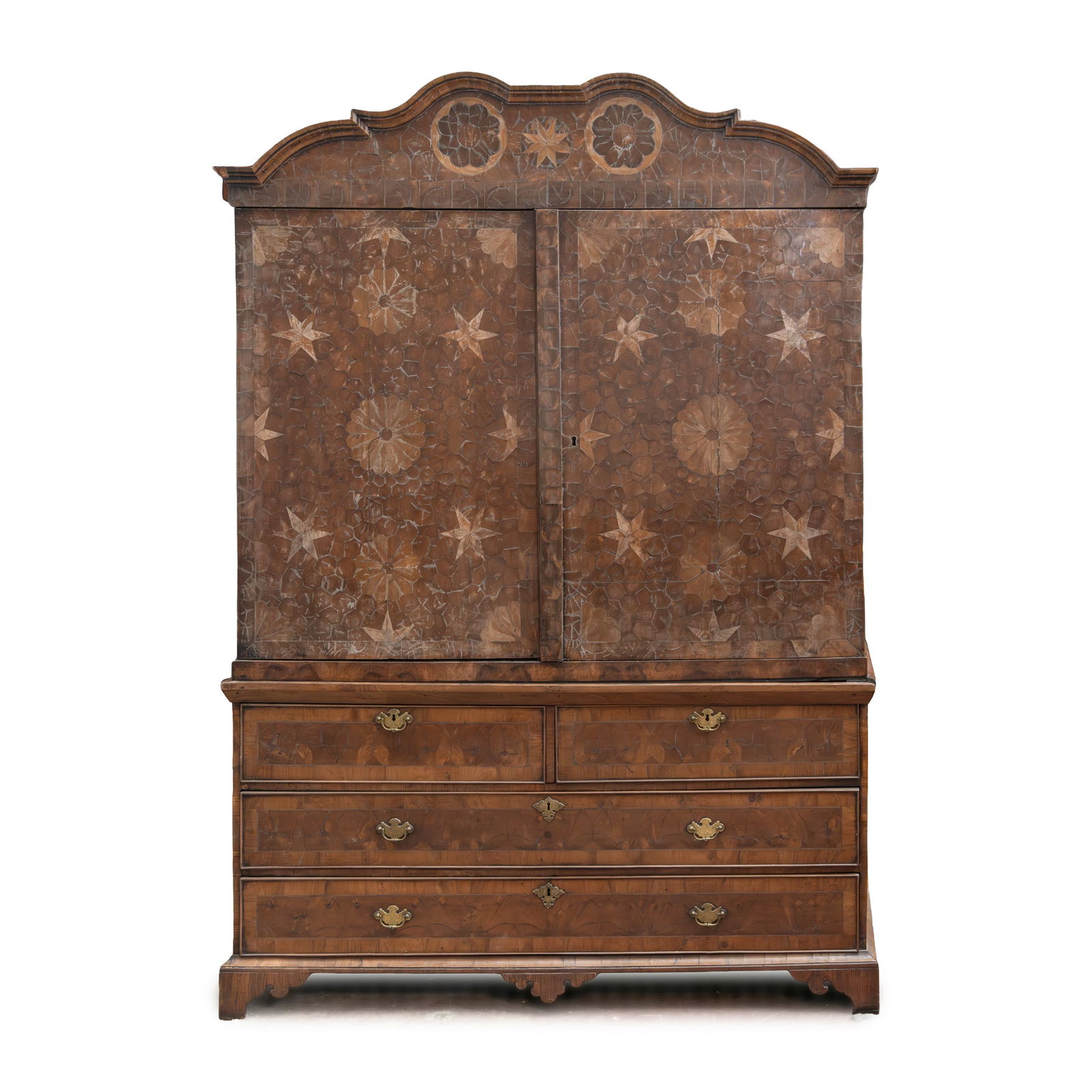 A DUTCH WALNUT OYSTER VENEER AND INLAID PRESS: A DUTCH WALNUT OYSTER VENEER AND INLAID PRESS 19TH CENTURY the moulded double arched cornice above a pair of doors with inlaid stars and flowerheads, the base with two short over two long drawers, bra