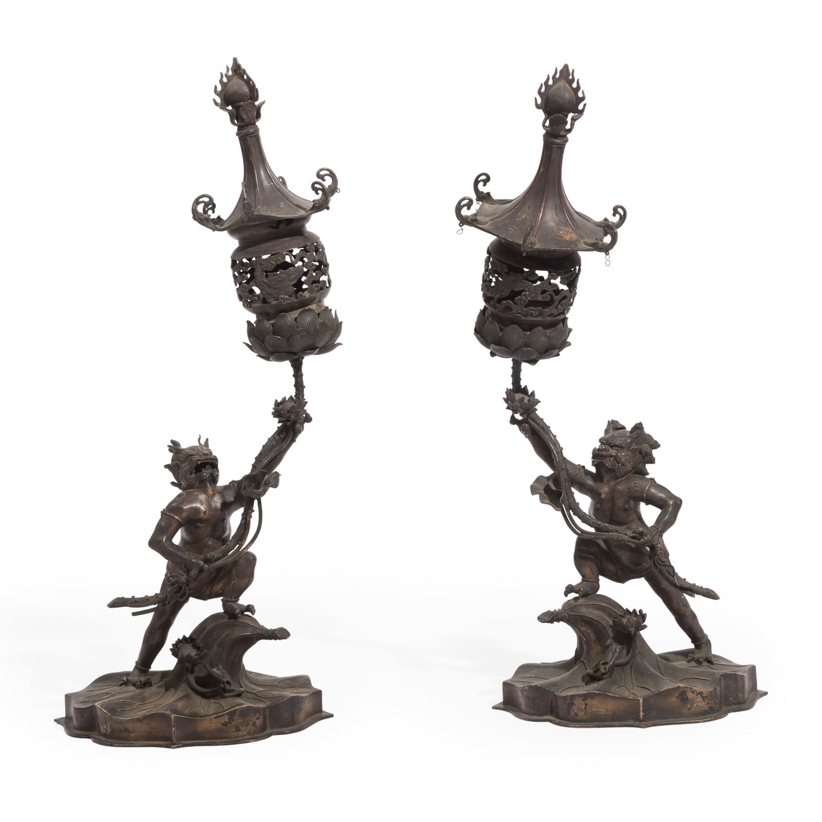 PAIR OF SOUTH EAST ASIAN PATINATED METAL LAMPS: PAIR OF SOUTH EAST ASIAN PATINATED METAL LAMPS EARLY 20TH CENTURY in the form of fearsome clawed deities on a lotus, holding a frond and pierced candle holder (2) 72cm high