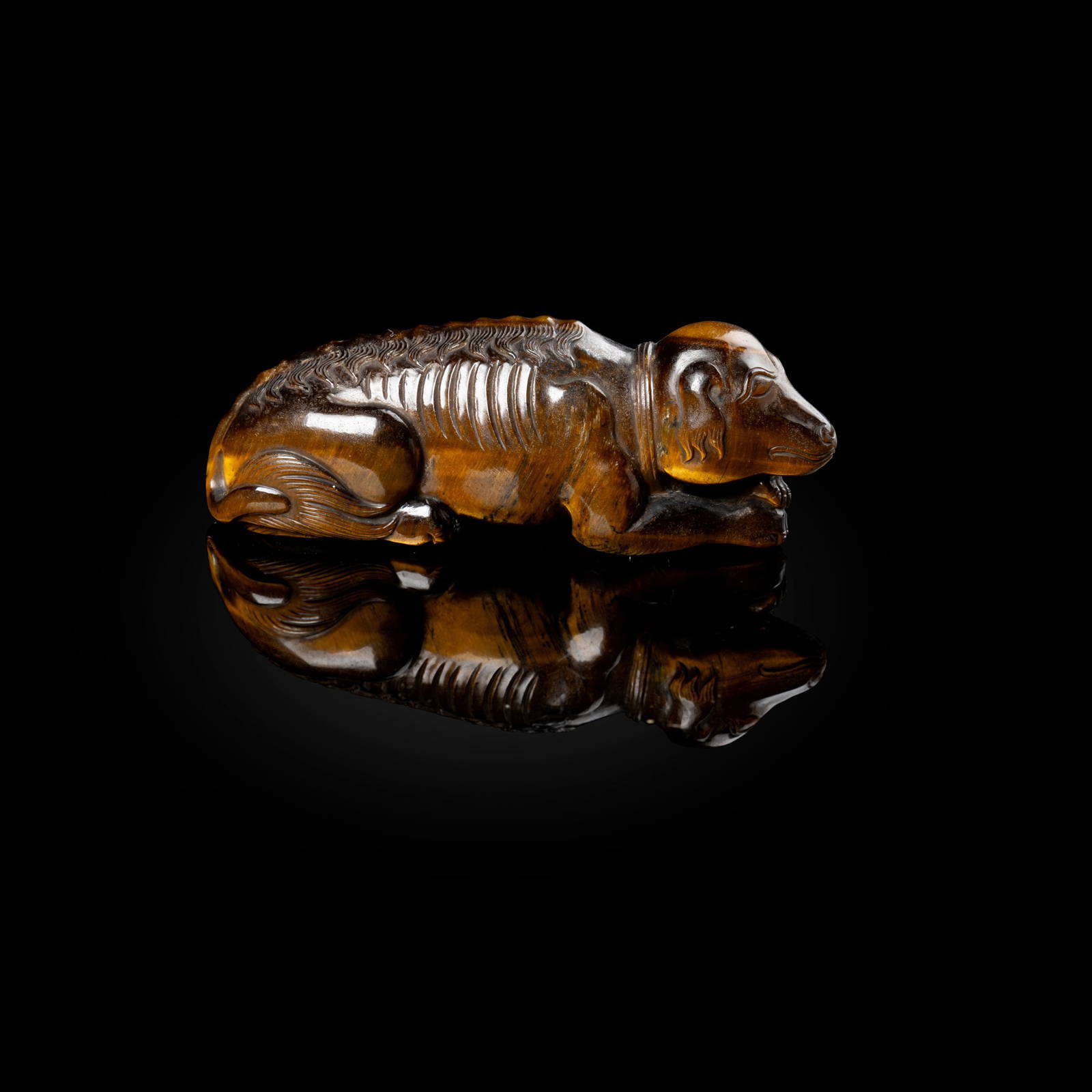 CHINESE TIGER'S EYE CARVING OF A RECUMBENT DOG