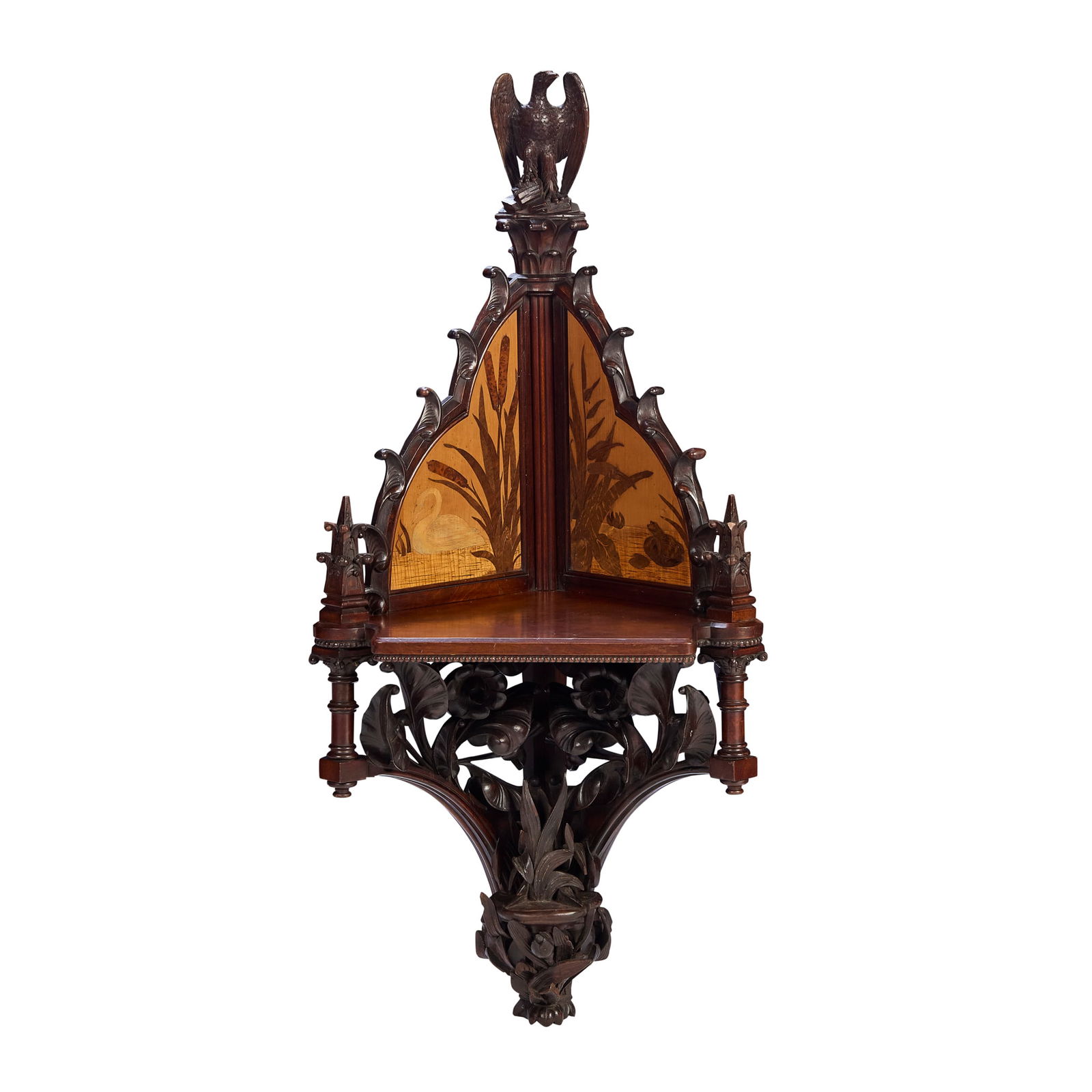 MANNER OF J. H. CHAMBERLAIN: MANNER OF J. H. CHAMBERLAIN GOTHIC REVIVAL CORNER WALL SHELF, CIRCA 1880 carved walnut, with marquetry inlaid panels 57cm wide, 129cm high, 42cm deep Frequently designing in the Ruskinian Gothic style