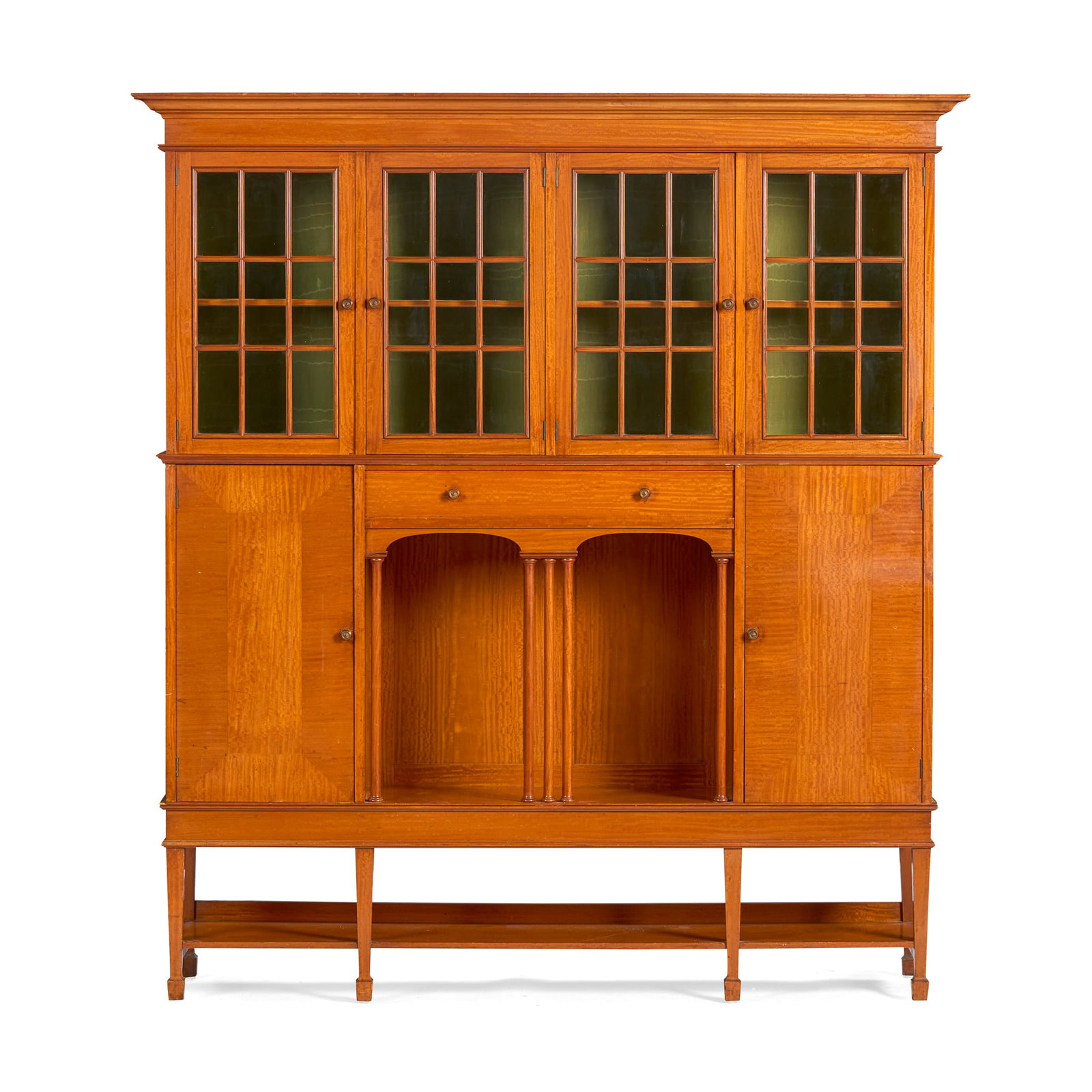 LIBERTY & CO., LONDON: LIBERTY & CO., LONDON DRAWING ROOM CABINET, CIRCA 1904 satinwood, with patinated brass handles, glazed doors enclosing silk-lined interior 167.5cm wide, 183.5cm high, 39.5cm deep Literature: Bennett D