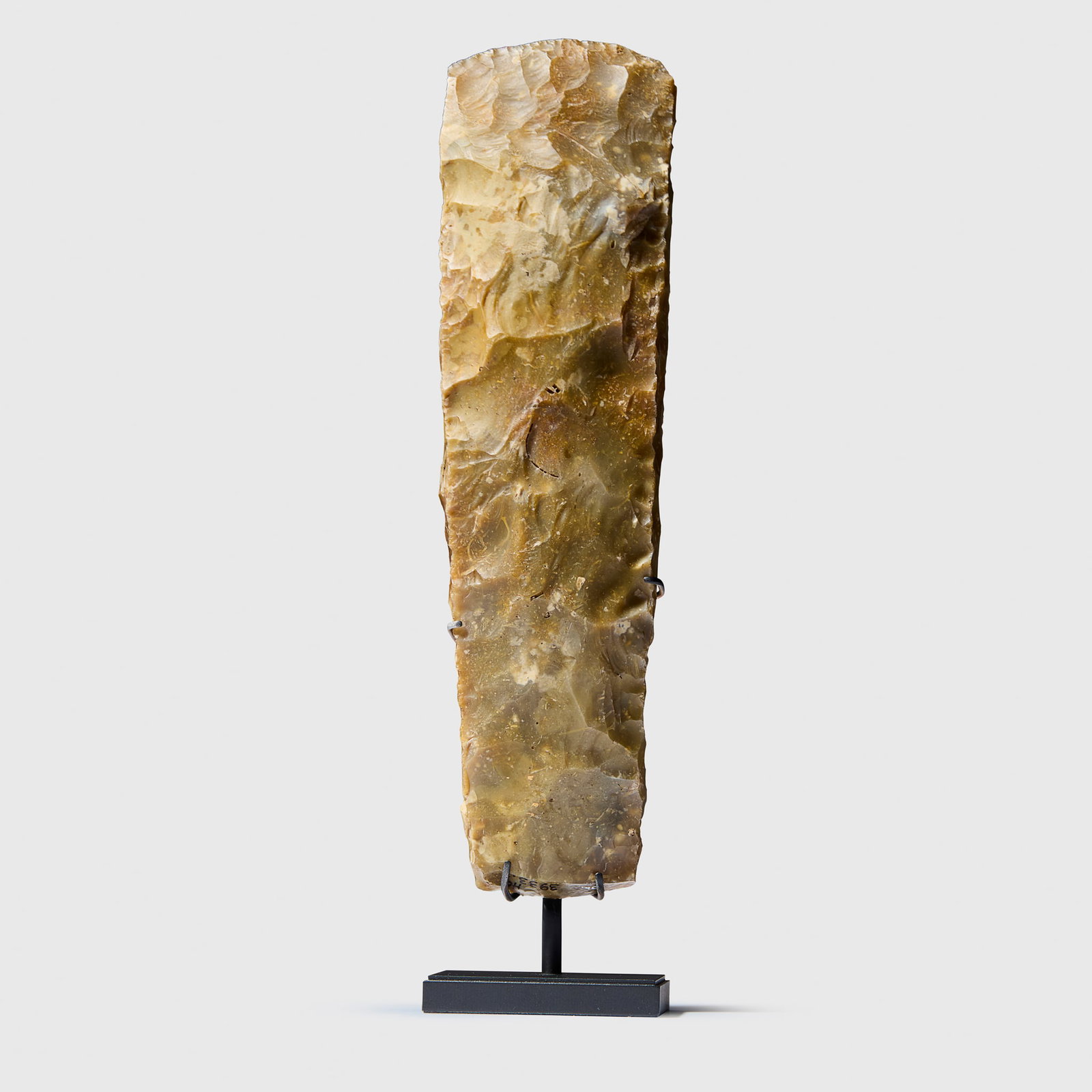 LARGE FLINT AXEHEAD: LARGE FLINT AXEHEAD SCANDINAVIA, 4000 - 3000 B.C. knapped flint, the stone worked into a rectangular form with a sharp tapering blade, finely flaked, displaying hues of mottled silver, raised on a