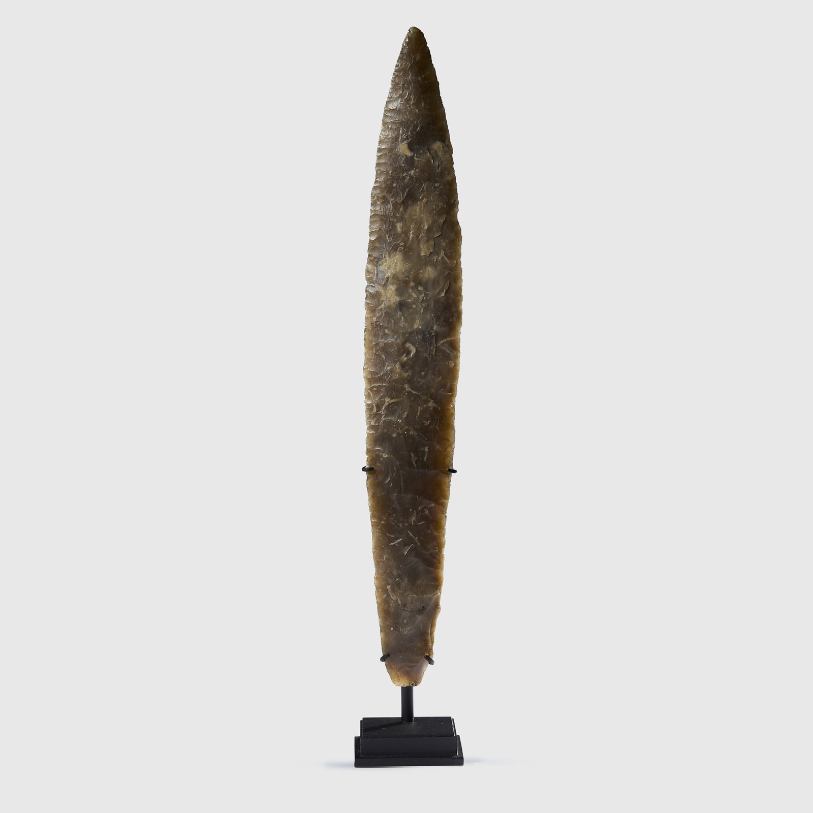 NEOLITIHIC FLINT DAGGER: NEOLITIHIC FLINT DAGGER TYPE I. SOUTHERN SCANDINAVIA, C. 2300 B.C. knapped light grey flint, of lanceolate form, tapering to a point, raised on a bespoke mount 26.2cm long Private collection, Denmark,