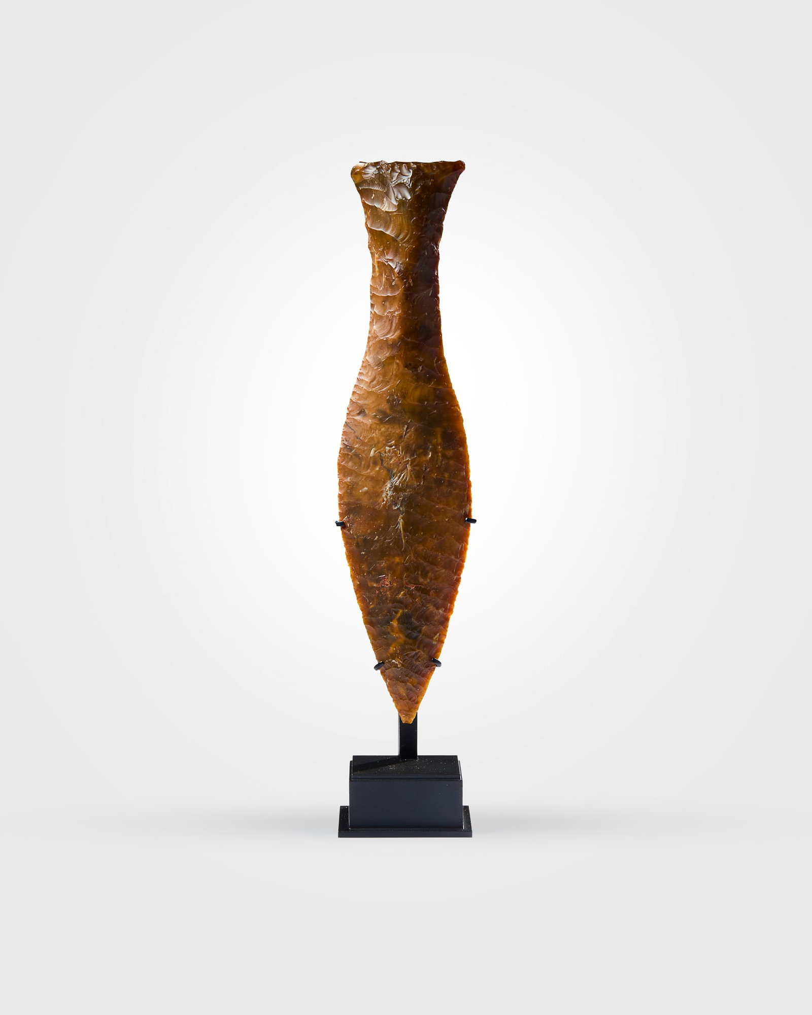 NEOLITIHIC FLINT DAGGER OF "FISHTAIL" TYPE: NEOLITIHIC FLINT DAGGER OF "FISHTAIL" TYPE TYPE V. SOUTHERN SCANDINAVIA, C. 2400 - 1800 B.C. knapped caramel and brown flint, with central ?stitching?, an elongated leaf shaped blade and thin handle t