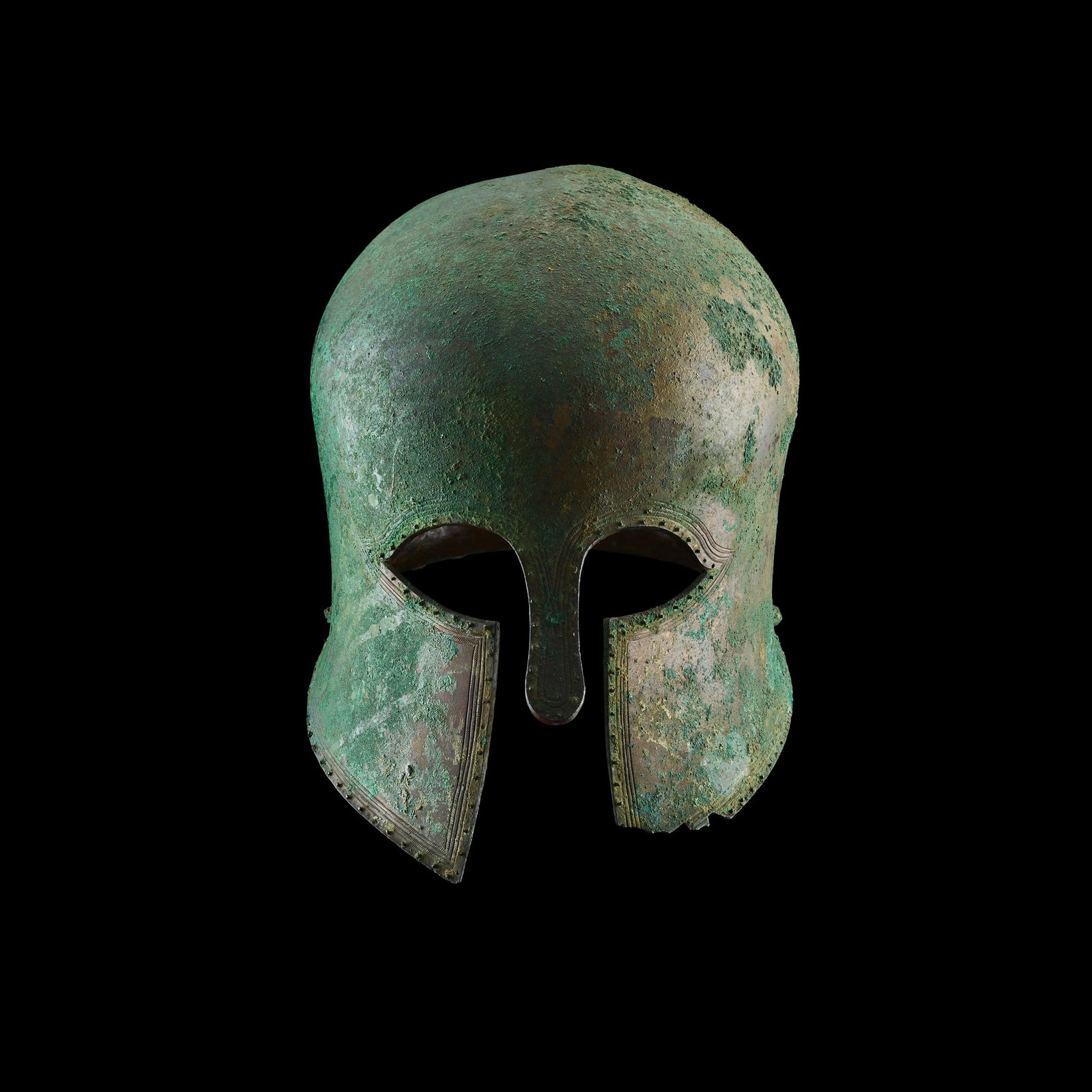 EXCEPTIONAL ANCIENT GREEK HELMET OF CORINTHIAN TYPE: EXCEPTIONAL ANCIENT GREEK HELMET OF CORINTHIAN TYPE GREECE, LATE ARCHAIC PERIOD, C. 525 - 475 B.C. hammered from a single piece of bronze, with a domed helm, flaring nose and cheek guards, almond-shap