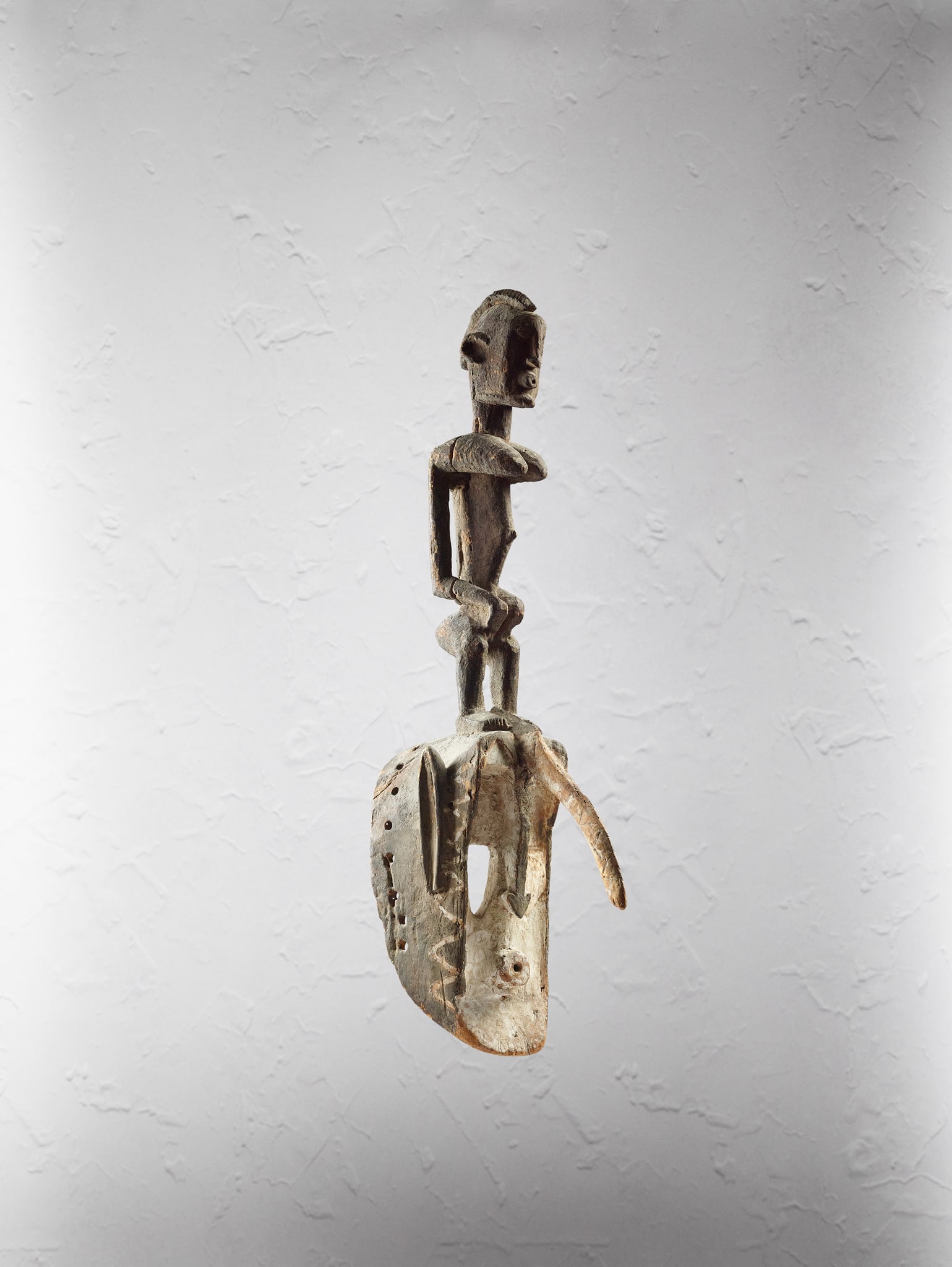 DOGON HORNBILL MASK, DYODYOMINI: DOGON HORNBILL MASK, DYODYOMINI MALI carved wood and pigment, openwork mask with protruding hornbill beak, above sits a female figure, with elongated proportions and stylised facial features, raised o