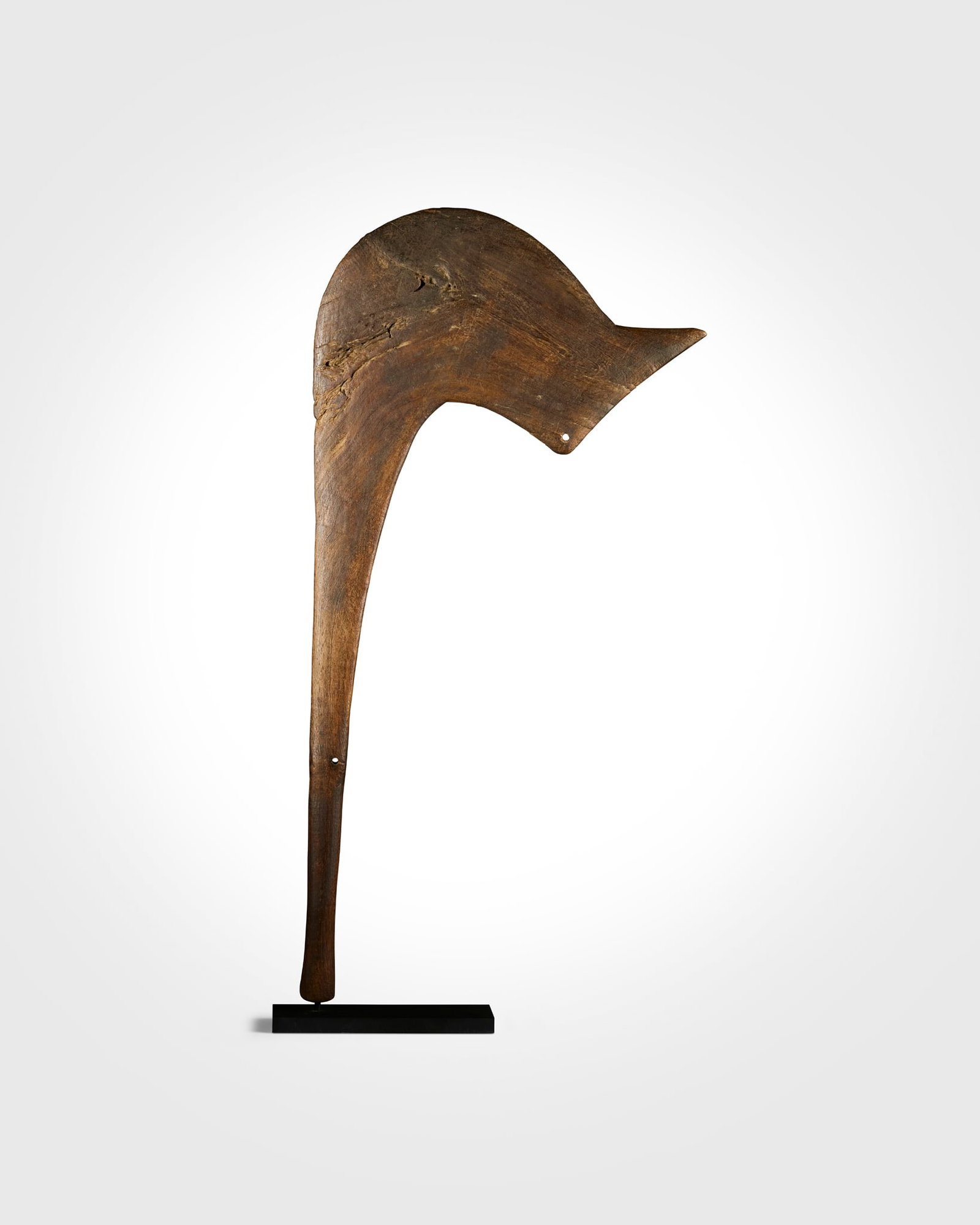 SENUFO DANCE SCEPTRE: SENUFO DANCE SCEPTRE COTE D'IVOIRE carved wood, the tapering shaft rising to a broad crescentic head, dark and aged patina, raised on a bespoke mount 77cm long A similar example from the collection of