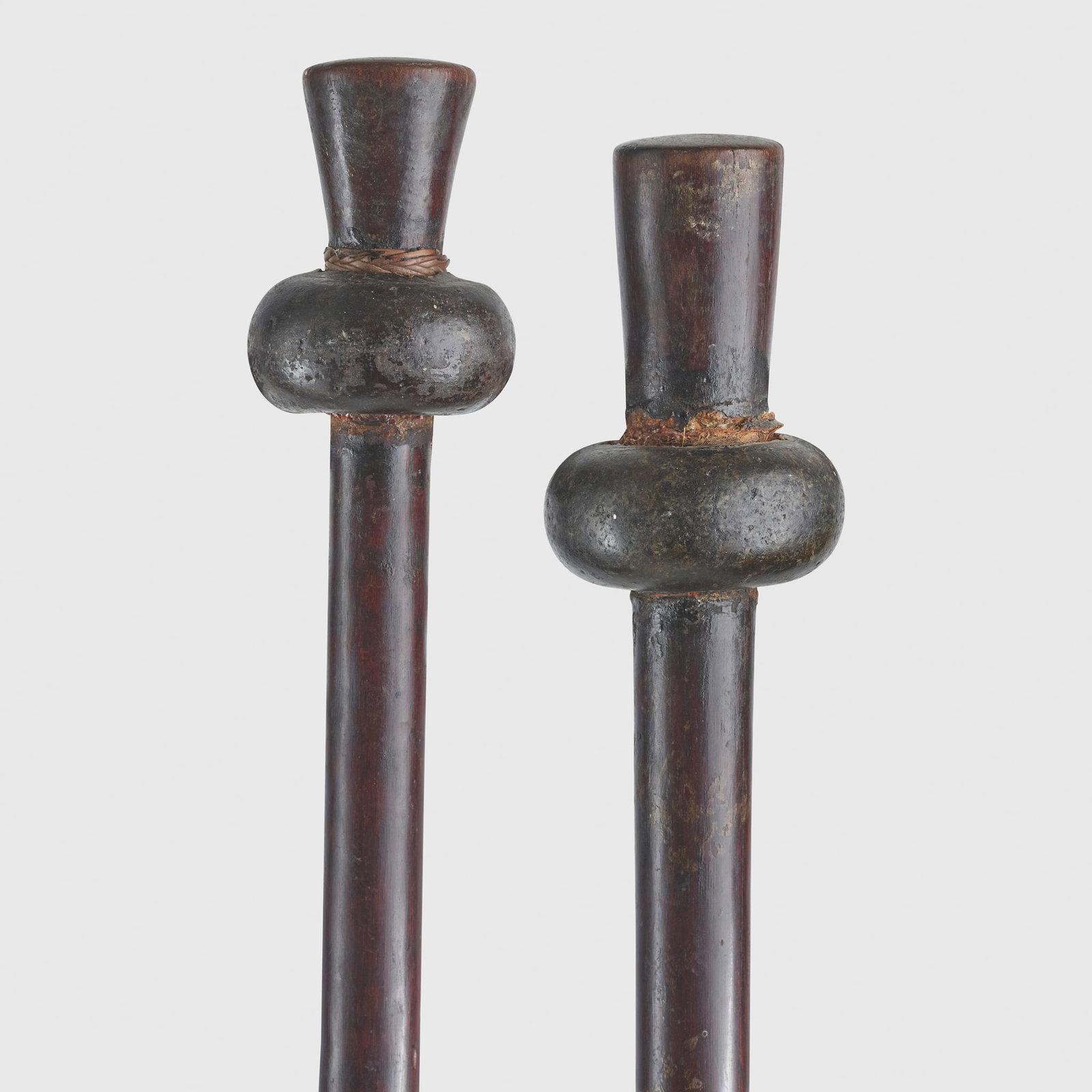 PAIR OF BAINING CLUBS: PAIR OF BAINING CLUBS NEW BRITAIN, PAPUA NEW GUINEA carved wood and greenstone, each with a long shaft, stepped butt and flaring top with inset carved greenstone head (2) 127.1 & 125cm long Private co