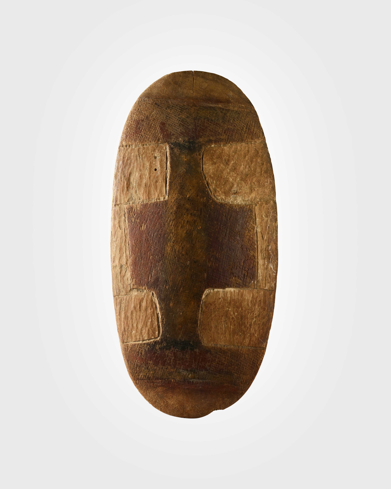 GULMARI SHIELD: GULMARI SHIELD NORTHEAST QUEENSLAND, AUSTRALIA carved wood and pigment, of oblong form, with squared recessed areas filled with lime pigment, an integral handle to the reverse 49.6cm tall Graham Turno
