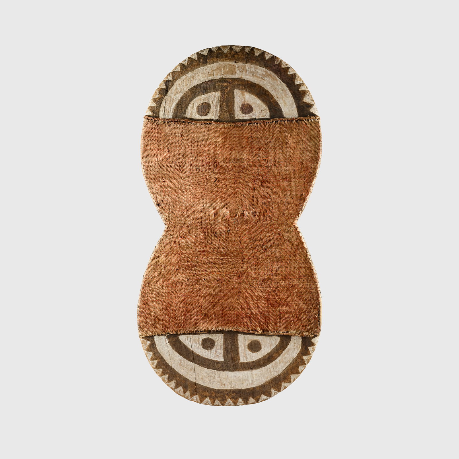 MOTU SHIELD: MOTU SHIELD CENTRAL PROVINCE, PAPUA NEW GUINEA, 19TH CENTURY carved wood, pigment and rattan, in figure-of-eight shape, the mid-section encased within a rattan binding, the surface decoration accented