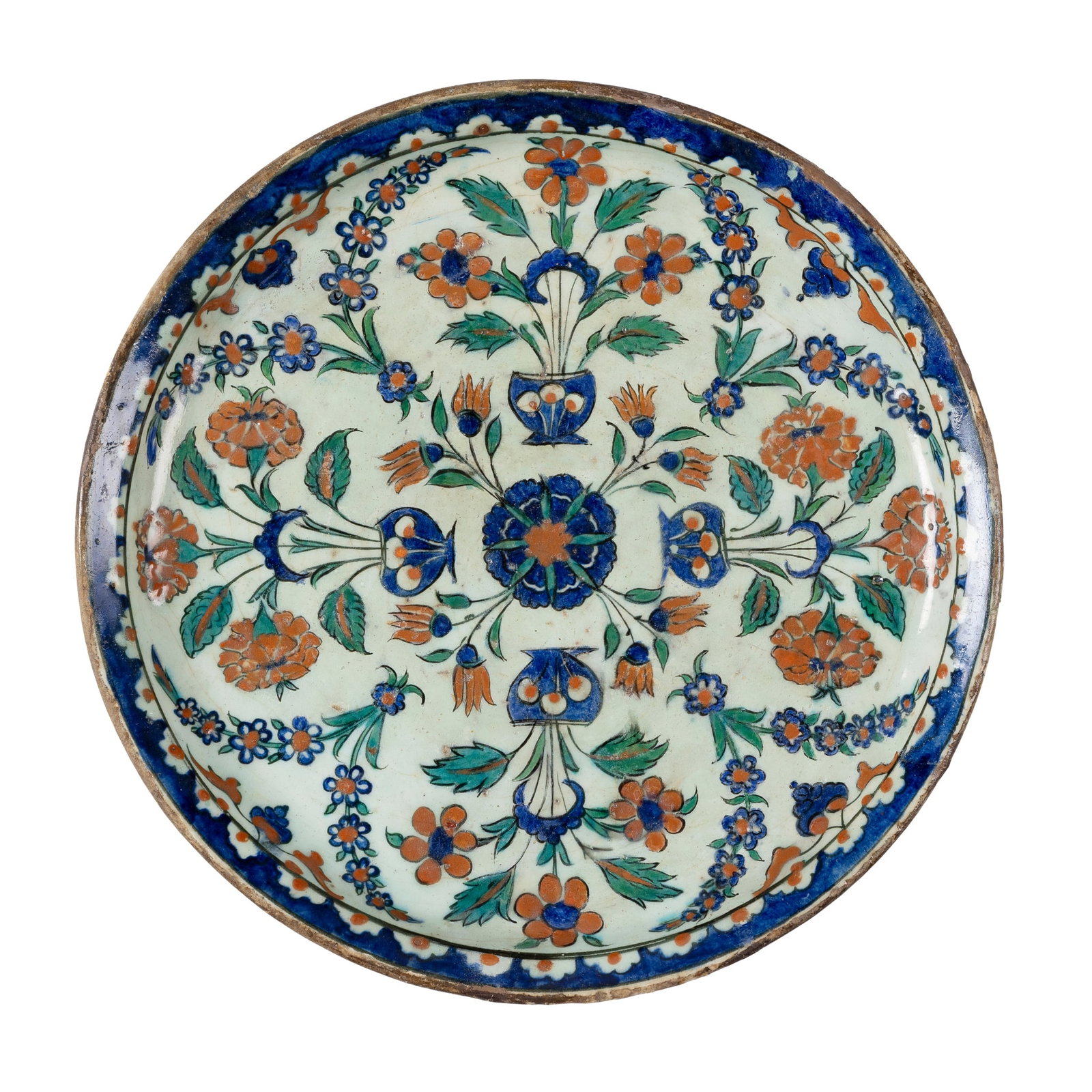 A RARE RIMLESS IZNIK 'QUATRE BOUQUETS' POTTERY DISH: A RARE RIMLESS IZNIK 'QUATRE BOUQUETS' POTTERY DISH OTTOMAN TURKEY, CIRCA 1575 of shallow form with short curved rim on a short ring foot, decorated in cobalt blue, bole red, green and black outline o