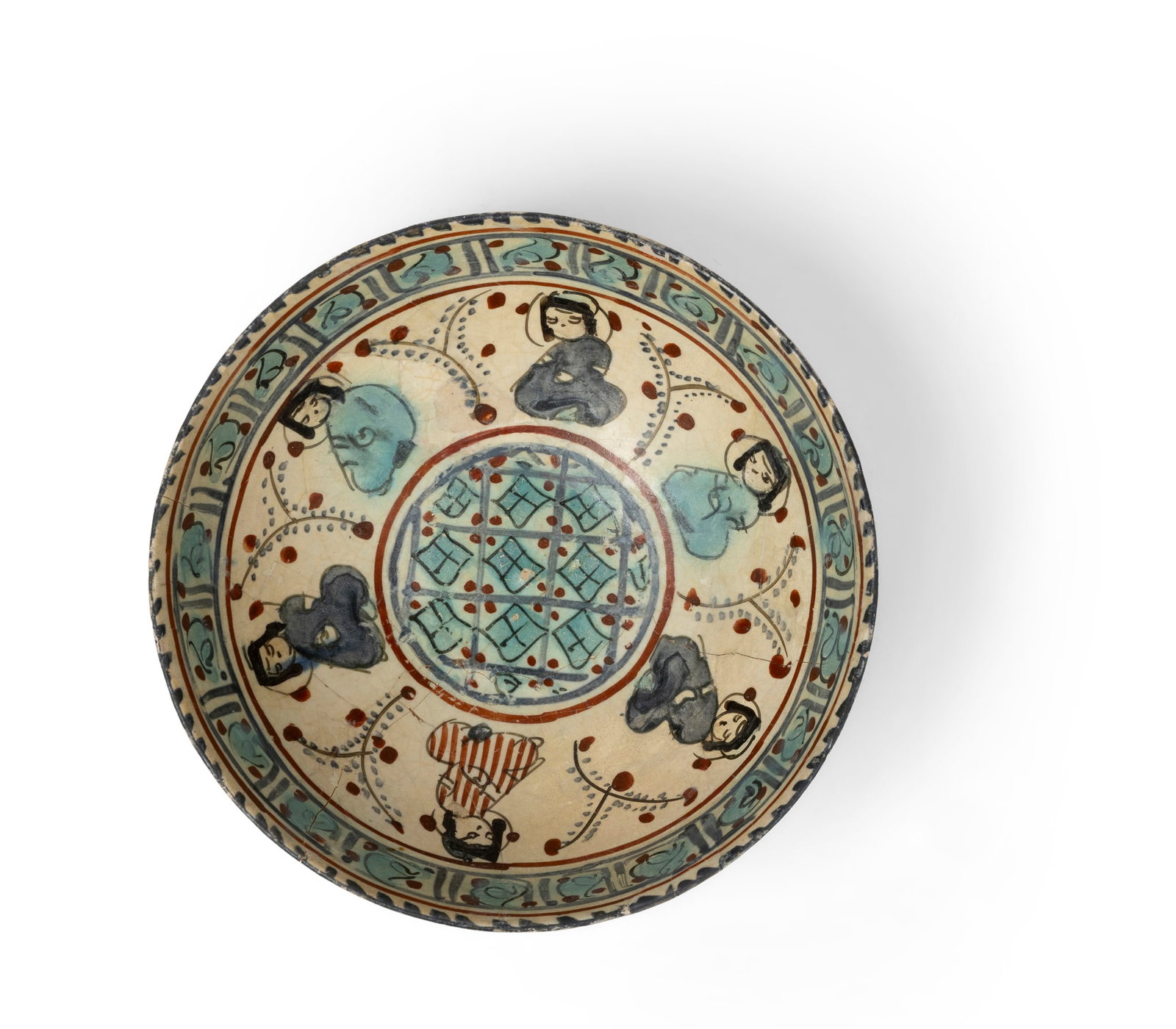 A MINAI POTTERY BOWL WITH FIGURES: A MINAI POTTERY BOWL WITH FIGURES PERSIA, 12TH/ 13TH CENTURY of deep rounded form on a short foot, decorated in polychrome on a cream ground with a central roundel containing a lattice design, surroun