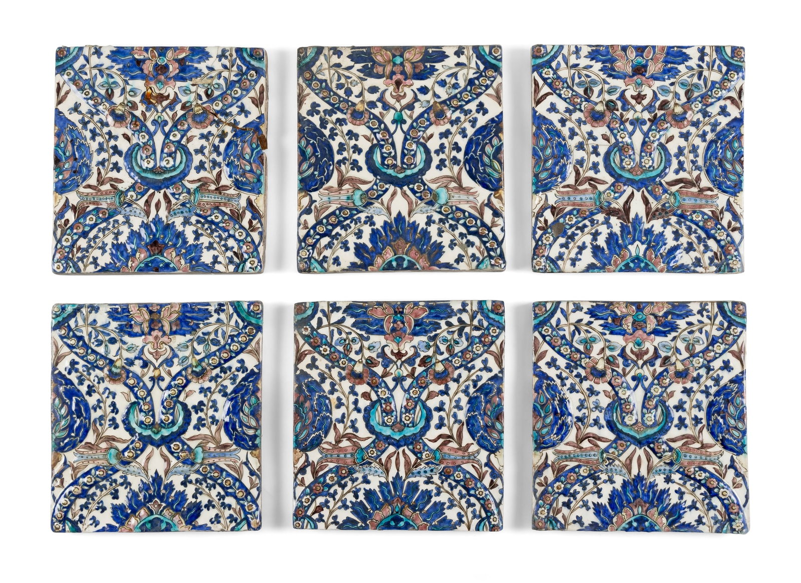 A GROUP OF QAJAR POTTERY TILES: A GROUP OF QAJAR POTTERY TILES PERSIA, 19TH CENTURY comprising six tiles of square form, moulded in relief and decorated in polychrome on a white ground under a transparent glaze, forming a symmetrica