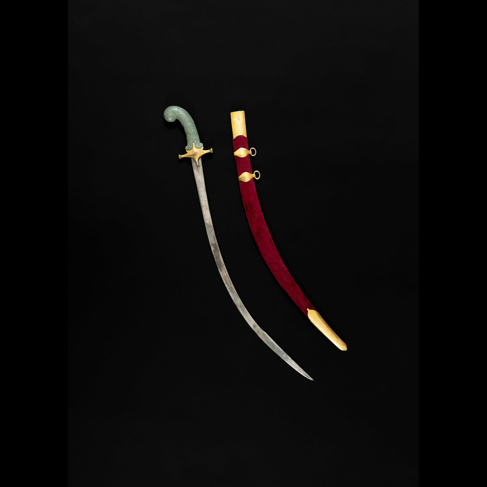 A MUGHAL JADE-HILTED STEEL SWORD (TALWAR): A MUGHAL JADE-HILTED STEEL SWORD (TALWAR) INDIA, 18TH/ 19TH CENTURY the single-edged slender water steel blade decorated with a band of elegant Bidri-style decoration forming floral motifs towards the