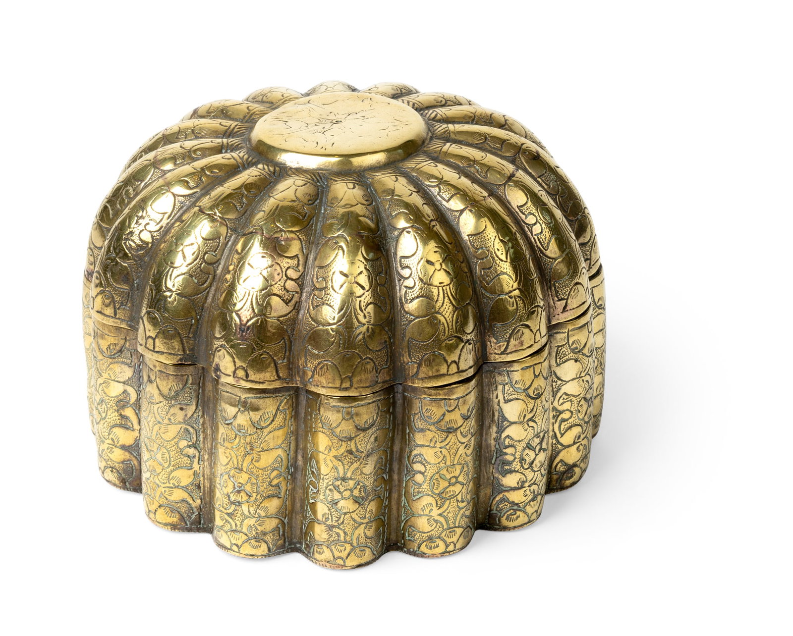 AN ELEGANT BRASS SPICE BOX OR PANDAN: AN ELEGANT BRASS SPICE BOX OR PANDAN NORTHERN INDIA, 18TH CENTURY of circular from, the ribbed body and domed detached lid engraved with continuous vegetal motifs 10cm high, diameter 14cm This b