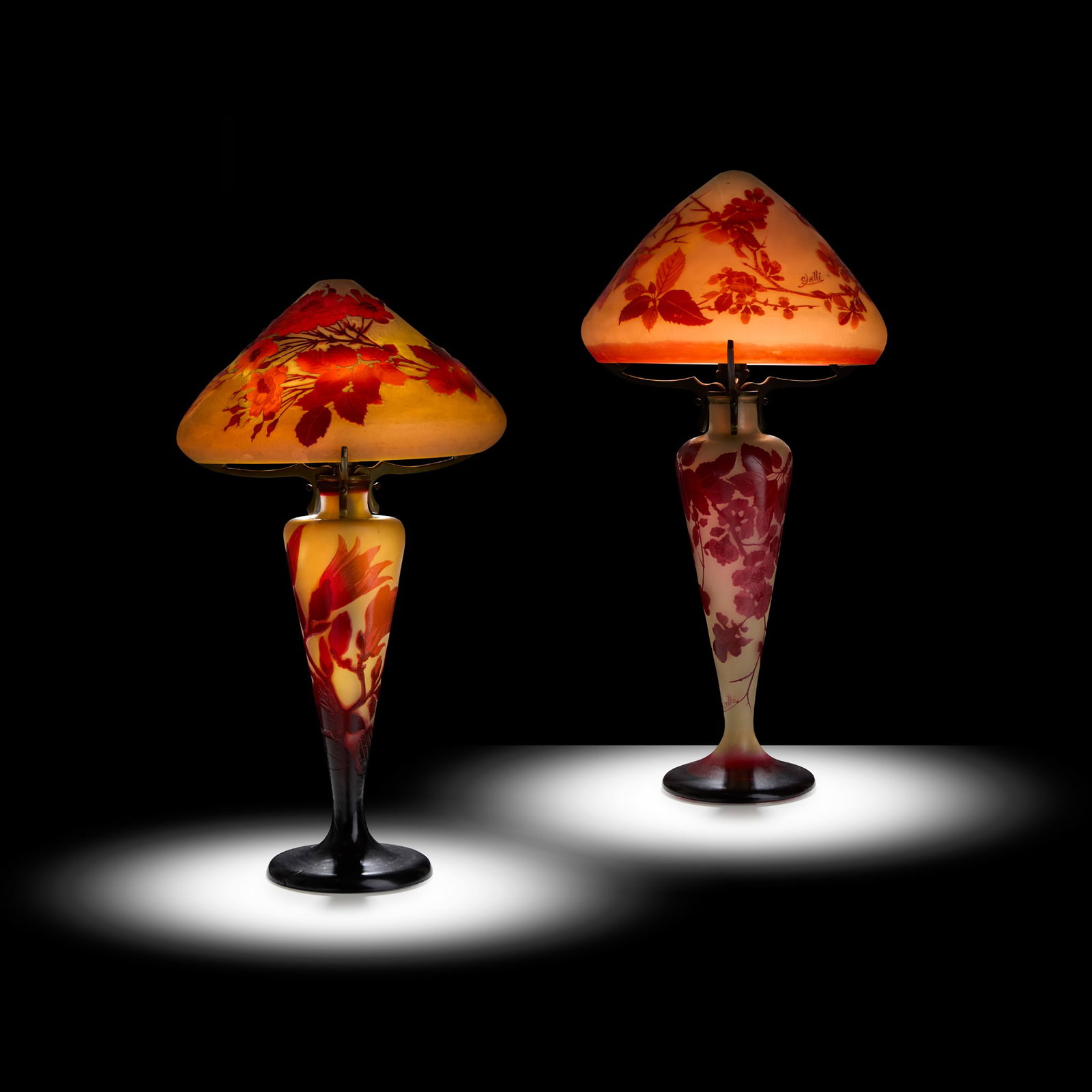 GALLÉ: GALLÉ TWO CAMEO GLASS TABLE LAMPS designed circa 1925overlaid and acid-etched glass, metal mounts, one decorated with flowering branches, the other with a magnolia design base and shade with flow
