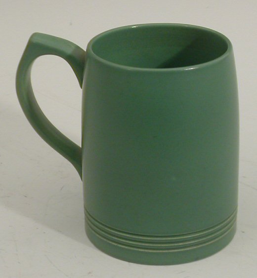 A Wedgwood tankard designed by Keith Murray, . of: A Wedgwood tankard designed by Keith Murray,. of cylindrical form with applied handle and ribbed base glazed in green, printed mark. 12cm high
