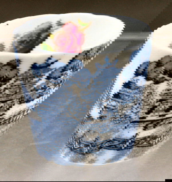 A Miss Cranston's Tearoom egg cup: A Miss Cranston's Tearoom egg cup, of tapering cylindrical form, printed with the willow pattern in blue on white, printed mark 'Miss Cranston's' (hairline crack)4.9cm high