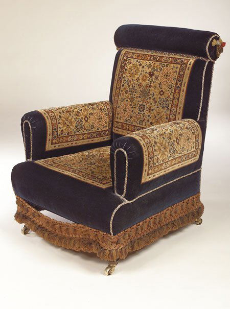 A Victorian carpet chair, by John Taylor & Sons,: A Victorian carpet chair, by John Taylor & Sons, Edinburgh, with royal blue velvet upholstery and turkey carpet panels, tassels and fringe, turned front legs and castors