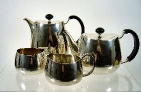 David Mellor (b. 1930) A 'Pride' electroplated tea: David Mellor (b. 1930) A 'Pride' electroplated tea service, designed c. 1959 for Walker and Hall, comprising: a teapot and cover; a hot water jug and cover; a milk jug; and a sugar bowl, each with sta