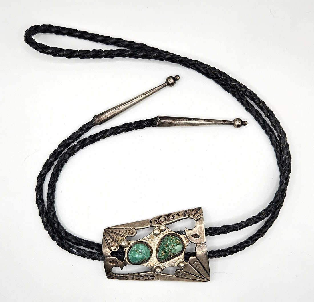 VINTAGE NAVAJO NATIVE AMERICAN STERLING SILVER TORQUOISE BOLO TIE: VINTAGE NAVAJO STERLING SILVER TORQUOISE BOLO TIE. Comes with leather cord, signed "STERLING". Size: bolo 2 1/2 x 2 in., total length 20 1/2 in. All measurements are approximate. Condition: Please see
