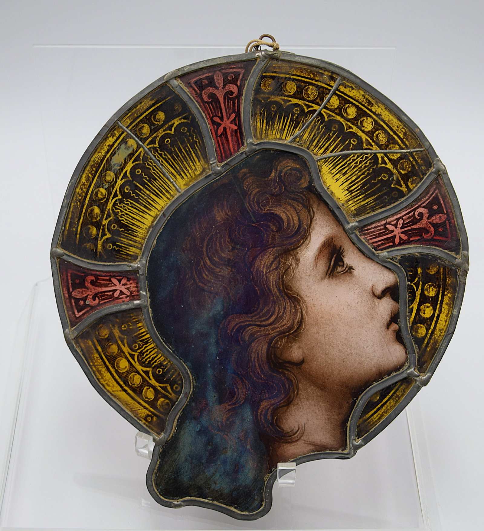 STAINED GLASS PANNEL VIRGIN MARY IN STYLE OF CHARLES O'NEILL: STAINED GLASS PANNEL VIRGIN MARY IN STYLE OF CHARLES O'NEILL. C. Late 19th/early 20th Century, an Arts and Crafts style stained and leaded glass semi circular panel depicting the Virgin Mary(?). Size: