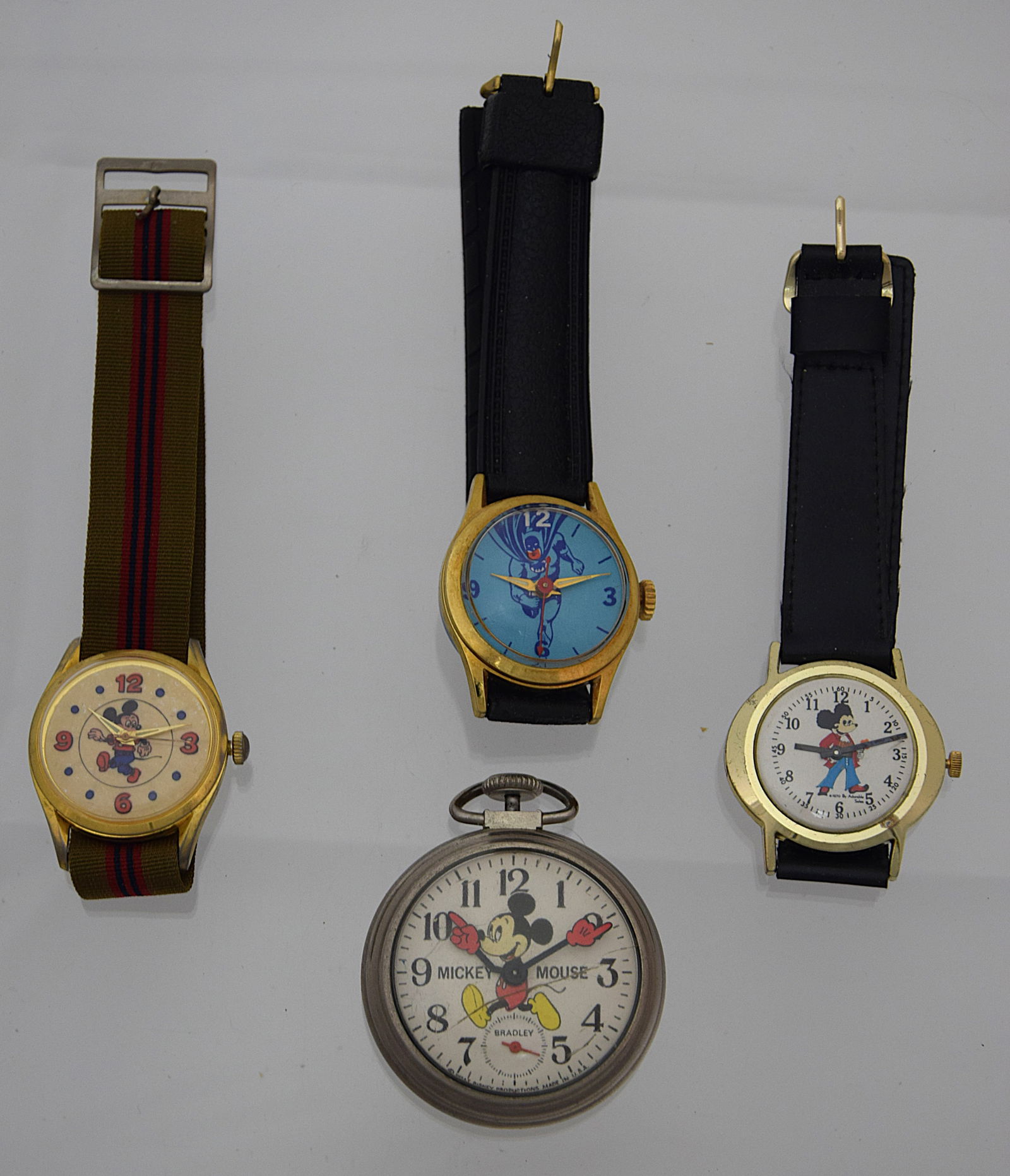 LOT OF 4 VINTAGE MICKEY MOUSE & BATMAN MECHANICAL/QUARTZ WRIST & POCKET WATCHES: LOT OF 4 VINTAGE MICKEY MOUSE & BATMAN MECHANICAL/QUARTZ WRIST & POCKET WATCHES. SWISS/USA MADE. Size: Case app. wrist watches 33, 34, 35mm; pocket watch 50mm excluding crowns. Condition: Some Working