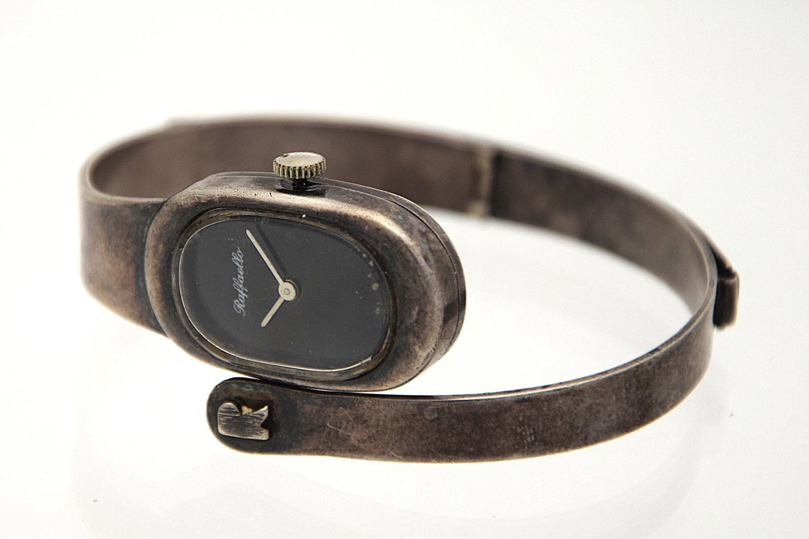 RAFFAELLO STERLING SILVER BANGLE SWISS MECHANICAL WRIST WATCH, C,1970: RAFFAELLO STERLING SILVER BANGLE SWISS MECHANICAL WRIST WATCH, C,1970. Size: Case app. 18mm x 29mm excluding crown. Condition: Working at the time of inspection. Please see pictures. Provenance: NYC p