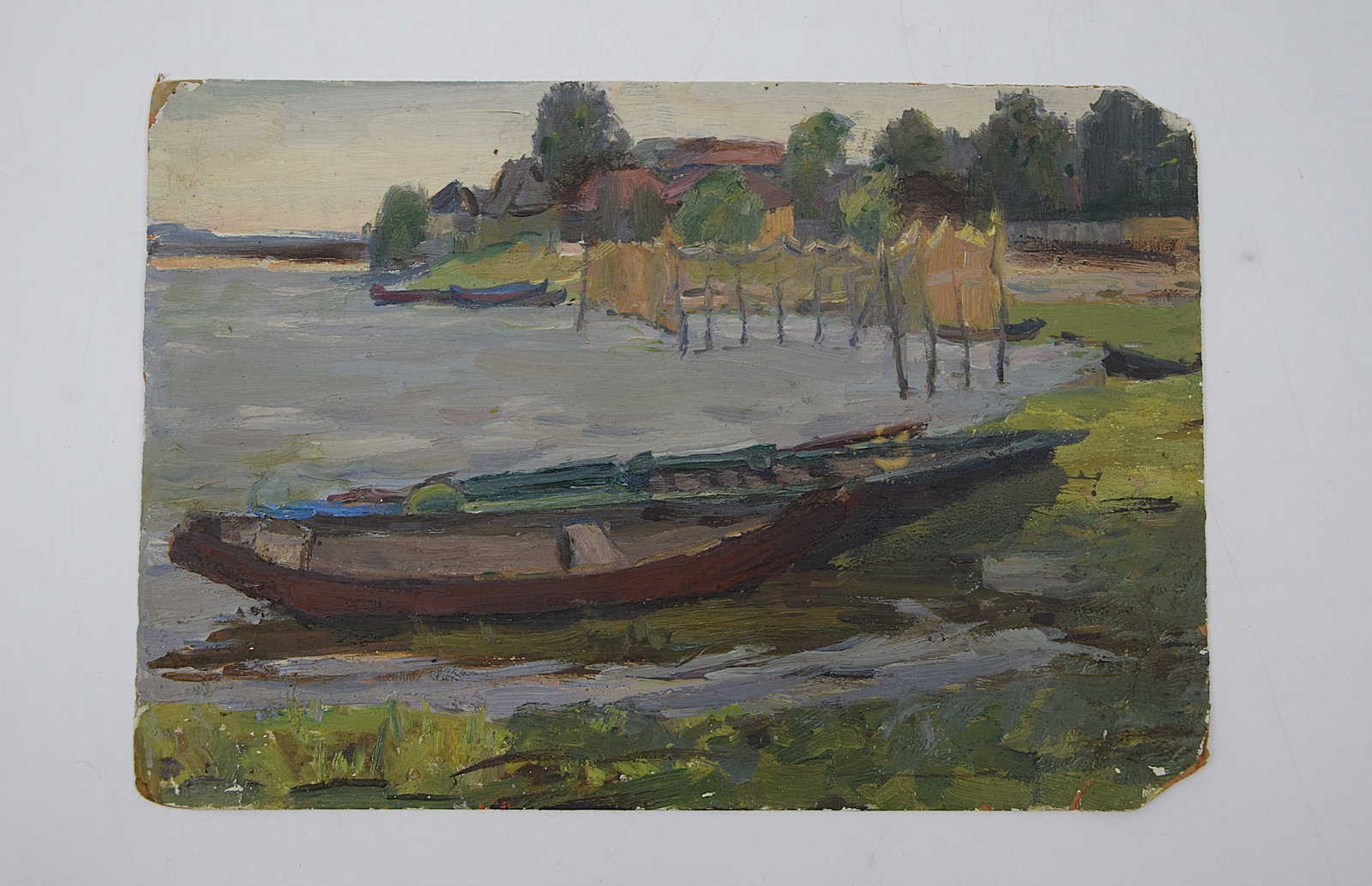 ORIGINAL OIL PAINTING “BOATS" BY NAZIM KHALVASH, DATED 1967 (RUSSIAN SCHOOL): ORIGINAL RUSIIAN SCHOOL OIL ON BOARD, DEPICTING A QUIET RIVERSIDE SCENE WITH WOODEN BOATS PULLED UP ALONG THE SHORE; IN THE MIDGROUND, SIMPLE STRUCTURES AND FISHING NETS DRY ON POLES, WITH TREES AND H